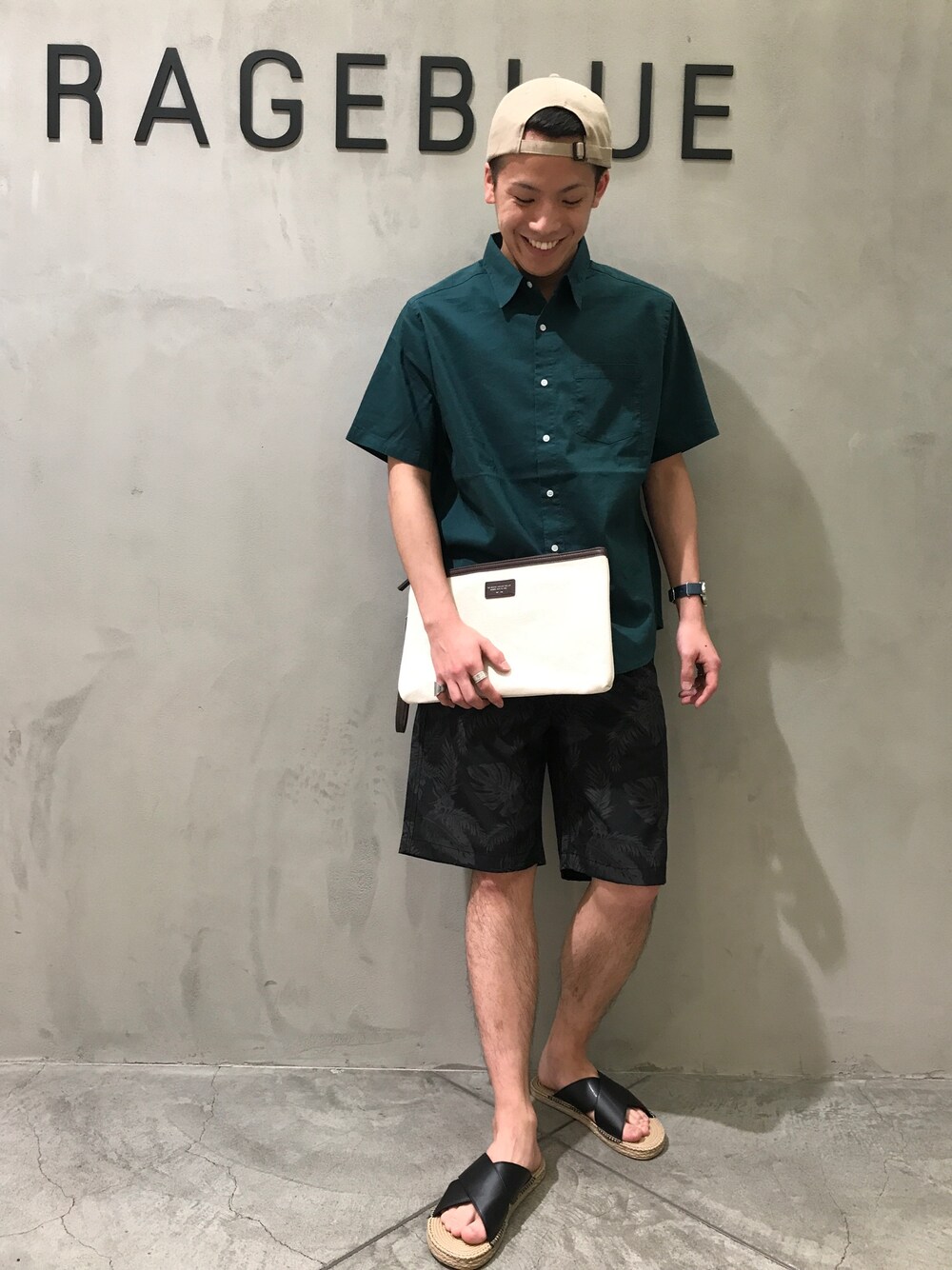 ホワイト系のクラッチバッグ、グリーン系のシャツ/ブラウス、グレー系のその他パンツを着用したメンズの夏コーディネートの1枚目の写真