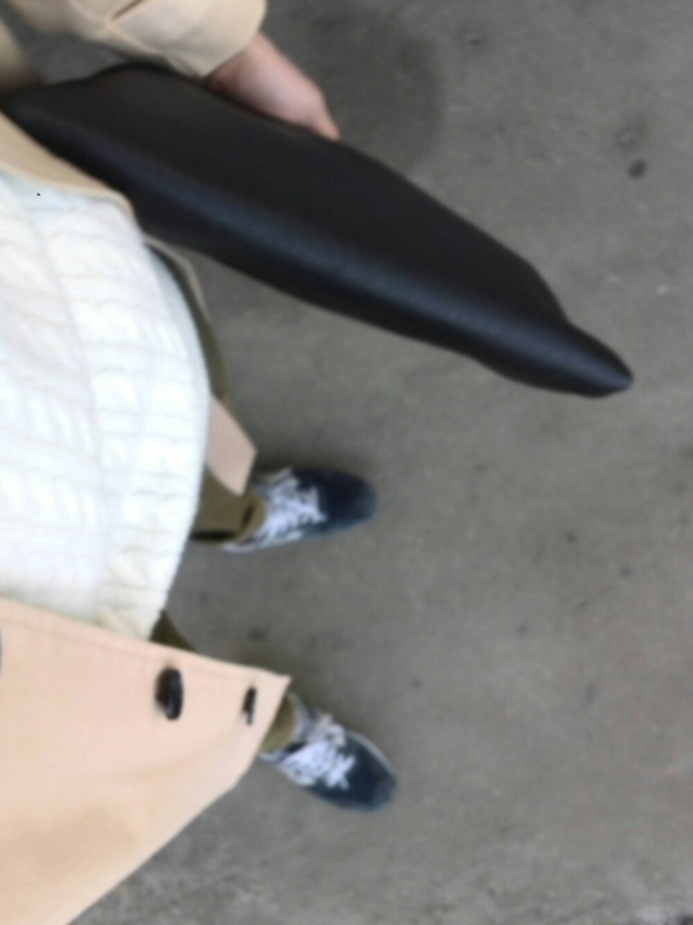 ホワイト系のニット/セーター、ブラック系のクラッチバッグ、ベージュ系のステンカラーコートを着用したメンズの冬コーディネートの1枚目の写真