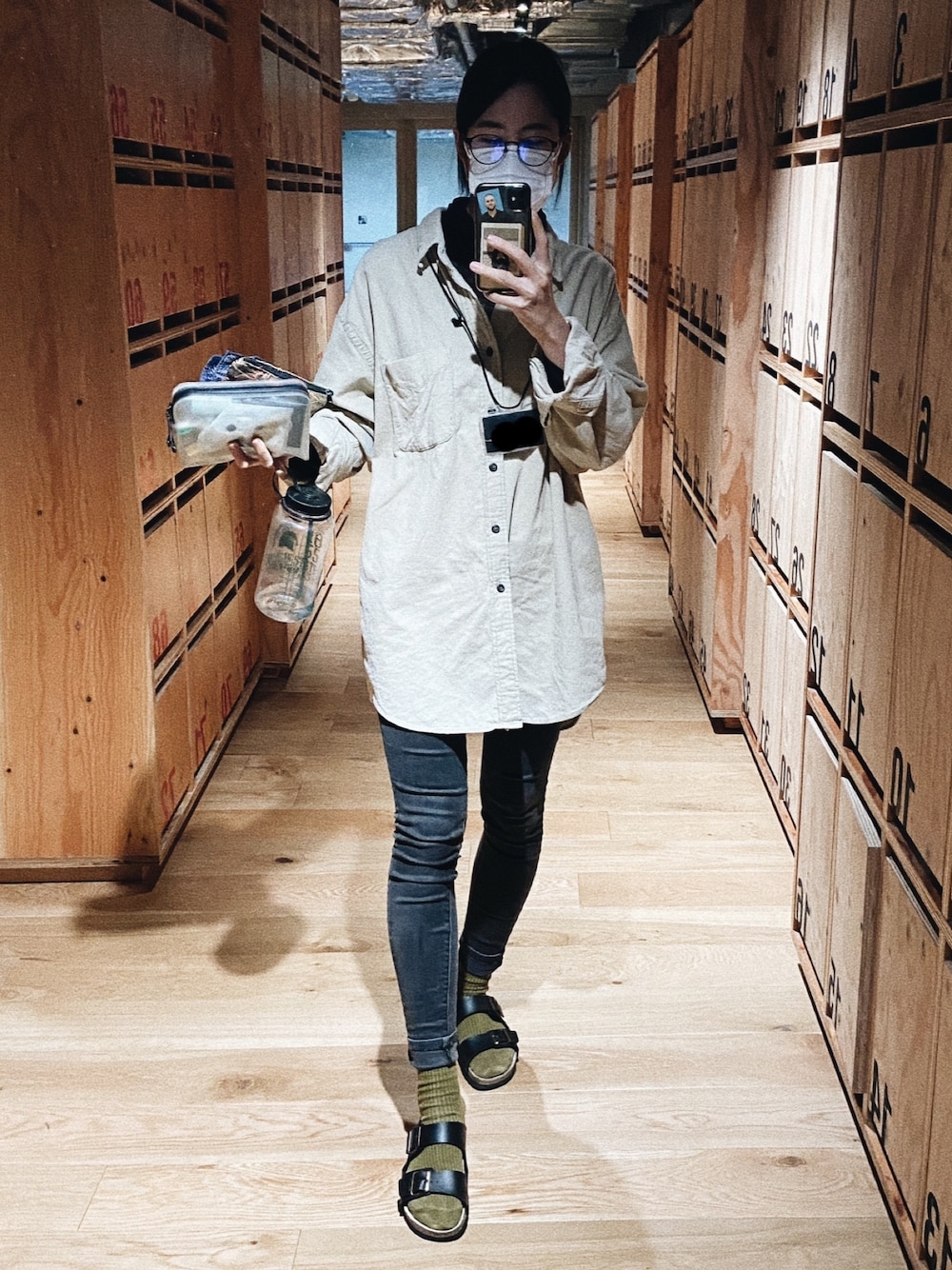 ブラック系のデニムパンツ、ベージュ系のシャツ/ブラウス、ブラック系のニット/セーターを着用したレディースの秋コーディネートの1枚目の写真