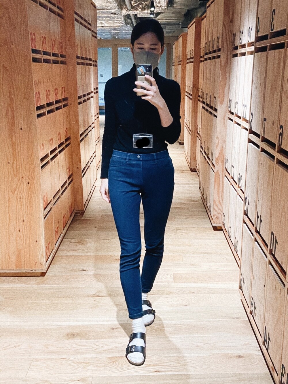 ブルー系のデニムパンツ、ブラック系のニット/セーターを着用したレディースの秋コーディネートの1枚目の写真