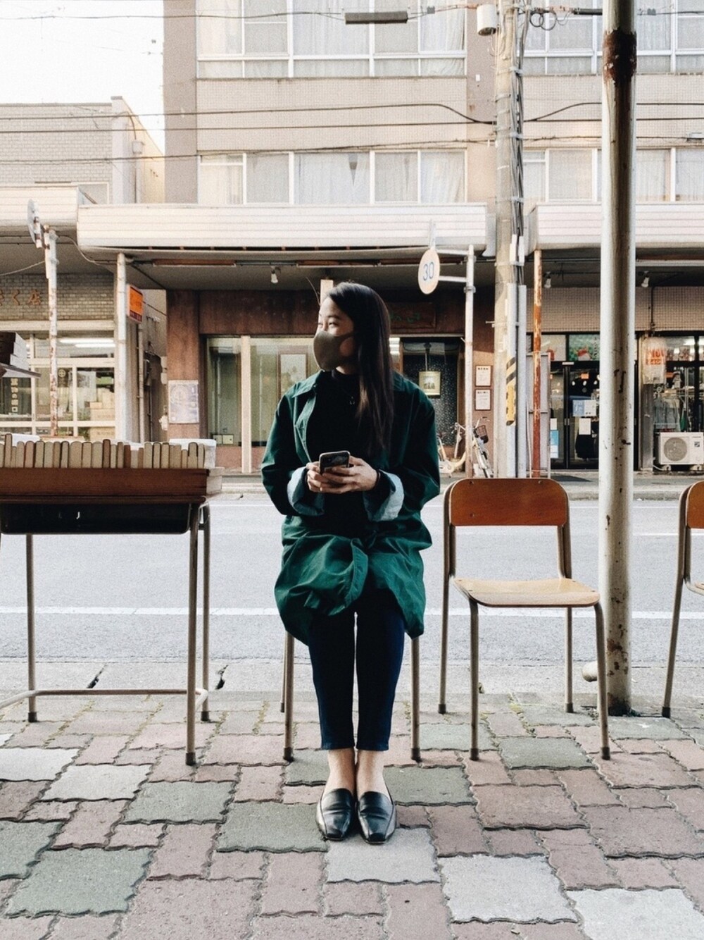 ブラック系のデニムパンツ、ブラック系のニット/セーター、グリーン系のジャケット/アウターを着用したレディースの秋コーディネートの1枚目の写真