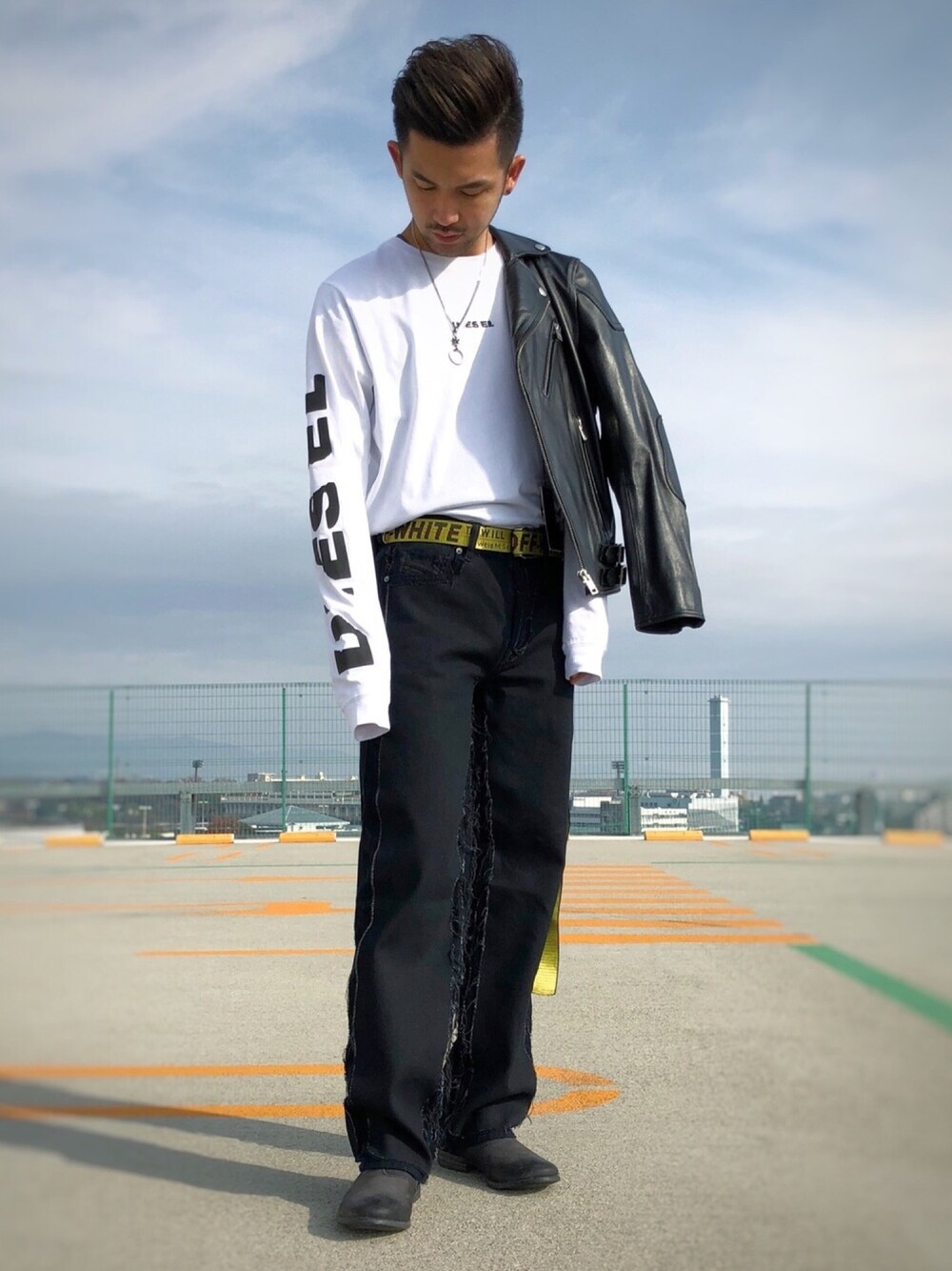 ブラック系のライダースジャケット、ホワイト系のTシャツ/カットソー、イエロー系のベルトを着用したメンズの冬コーディネートの1枚目の写真