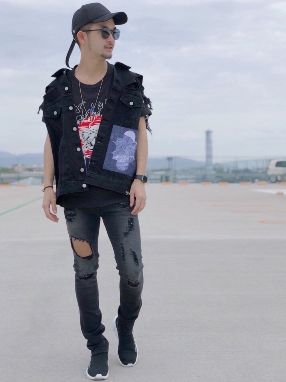 ブラック系のデニムジャケット、ブラック系のデニムパンツ、ブラック系のスニーカーを着用したメンズの春コーディネートの1枚目の写真