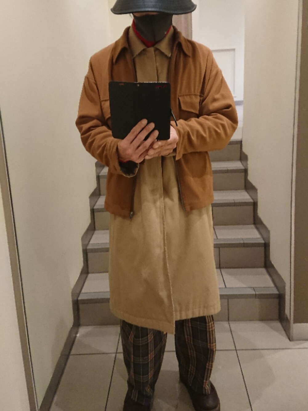 イエロー系のその他アウター、ベージュ系のステンカラーコート、ブラウン系のその他パンツを着用したメンズの冬コーディネートの1枚目の写真