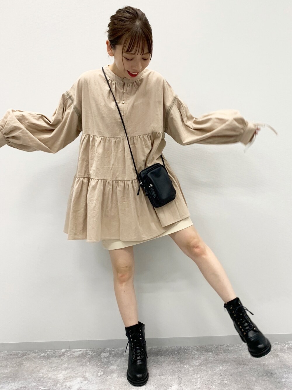 ベージュ系のシャツ/ブラウス、ブラック系のショルダーバッグ、ブラック系のブーツを着用したレディースの夏コーディネートの1枚目の写真