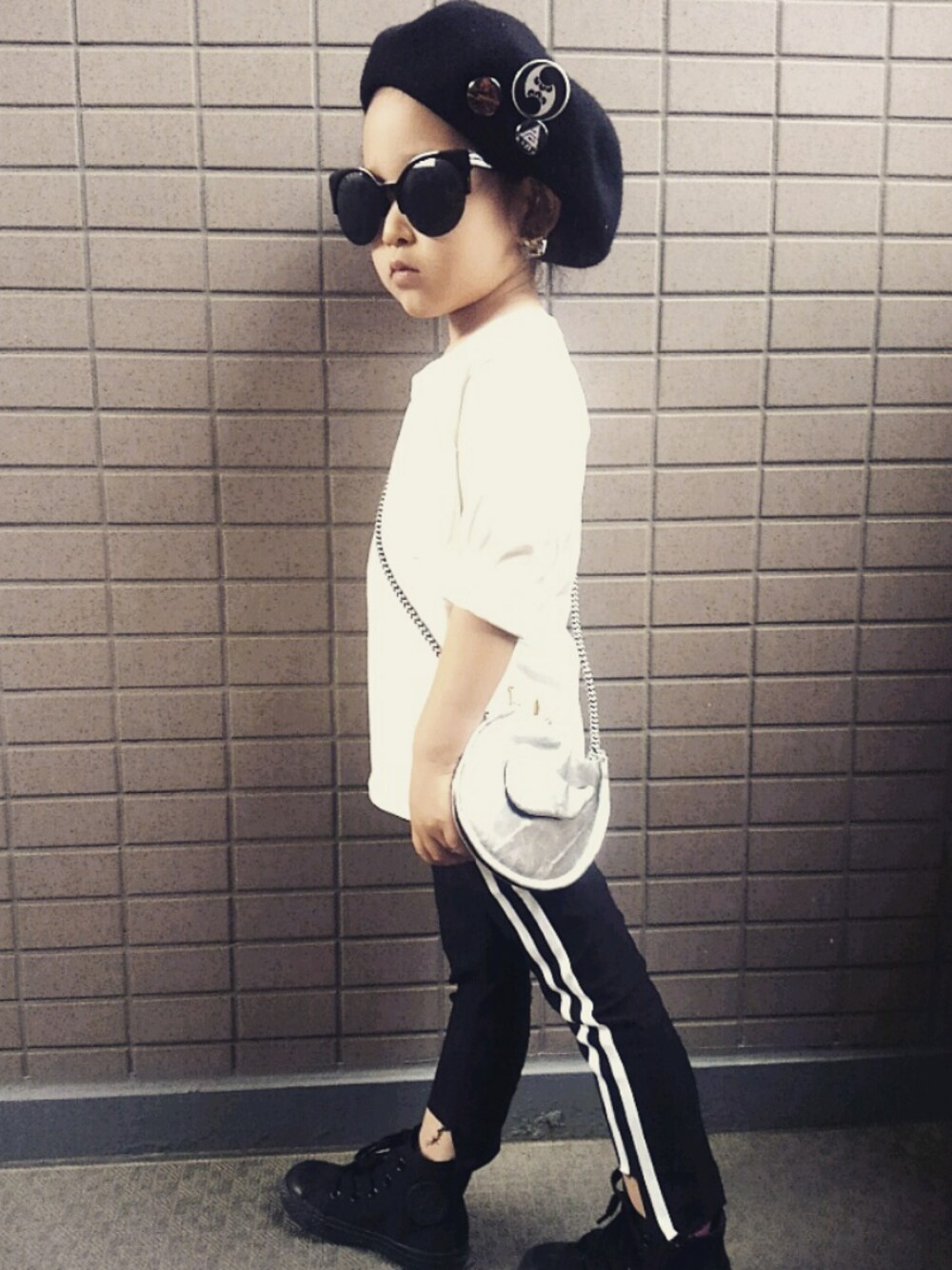 ブラック系のパンツ、ホワイト系のTシャツ/カットソー、シルバー系のショルダーバッグを着用したキッズの夏コーディネートの1枚目の写真