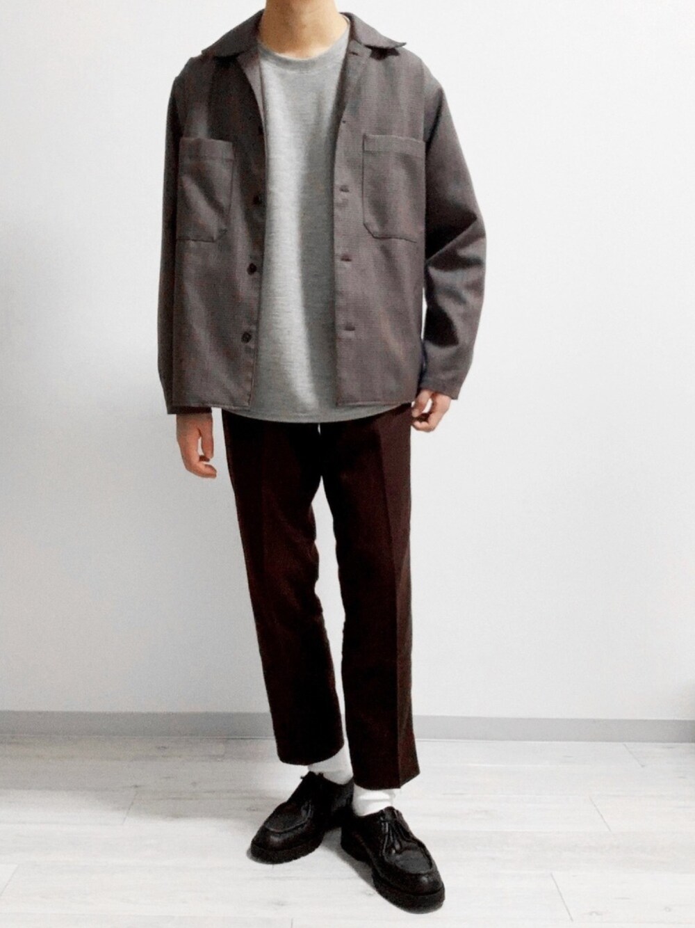 ブラウン系のスラックス、グレー系のシャツ/ブラウス、ブラック系のドレスシューズを着用したメンズの冬コーディネートの1枚目の写真