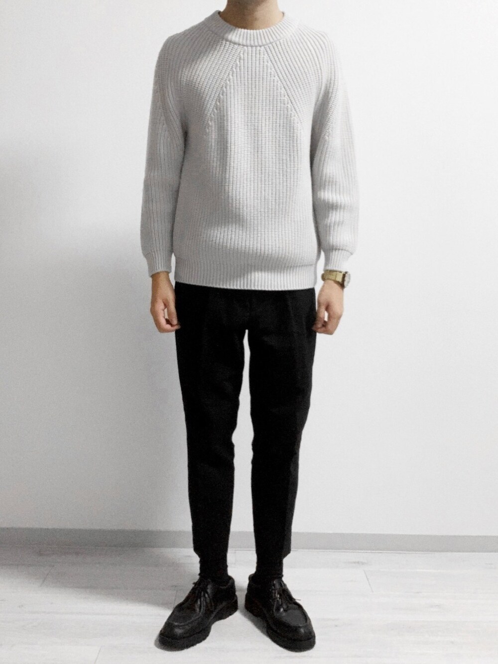 ホワイト系のニット/セーター、ブラック系のスラックス、ブラック系のドレスシューズを着用したメンズの冬コーディネートの1枚目の写真