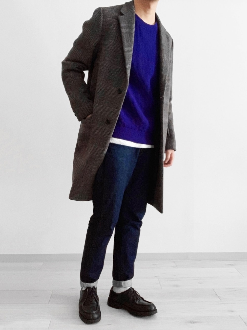 ブルー系のデニムパンツ、グレー系のチェスターコート、ブルー系のニット/セーターを着用したメンズの冬コーディネートの1枚目の写真