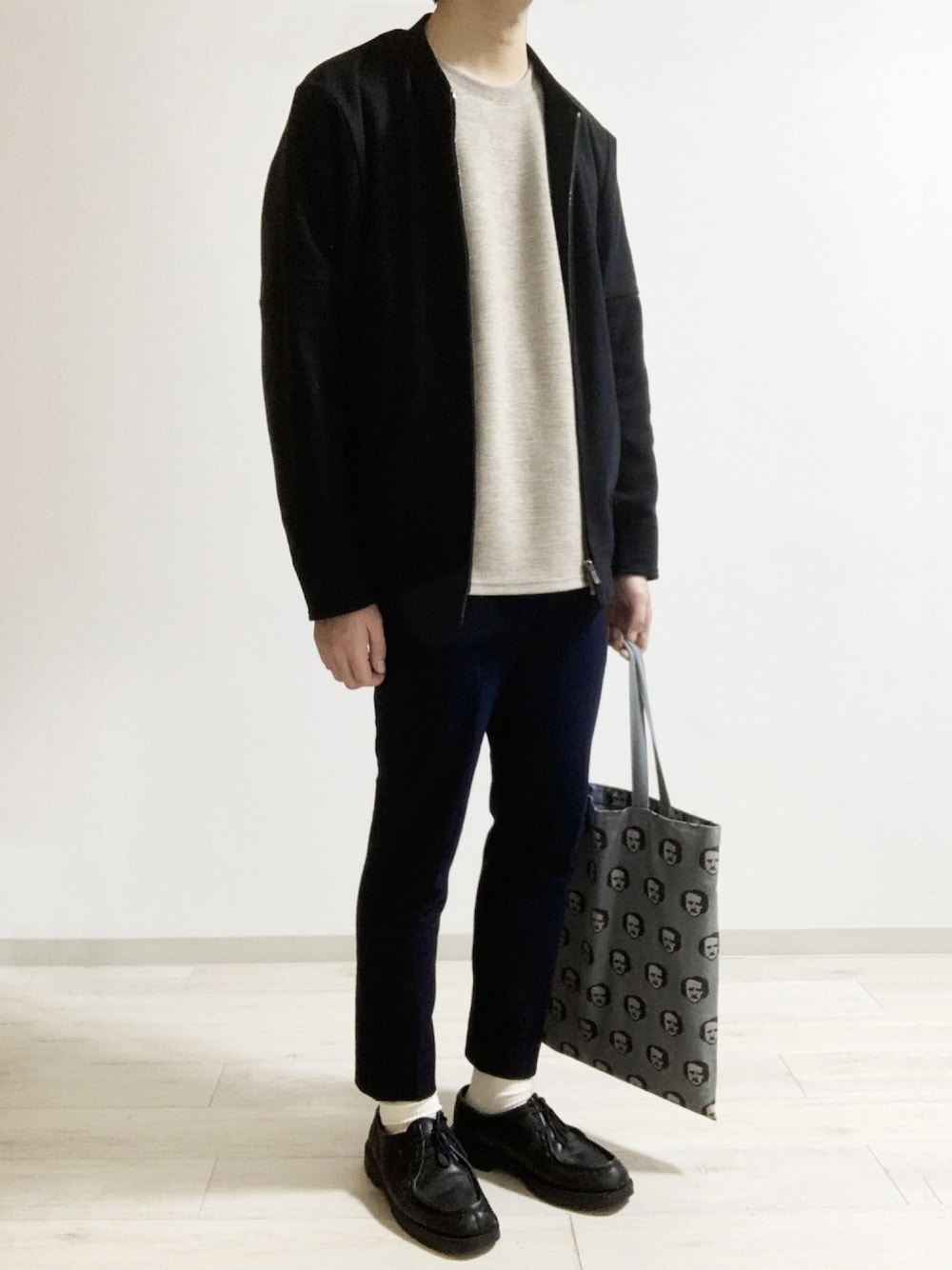 ブラック系のノーカラージャケット、ベージュ系のTシャツ/カットソー、ブラック系のドレスシューズを着用したメンズの冬コーディネートの1枚目の写真