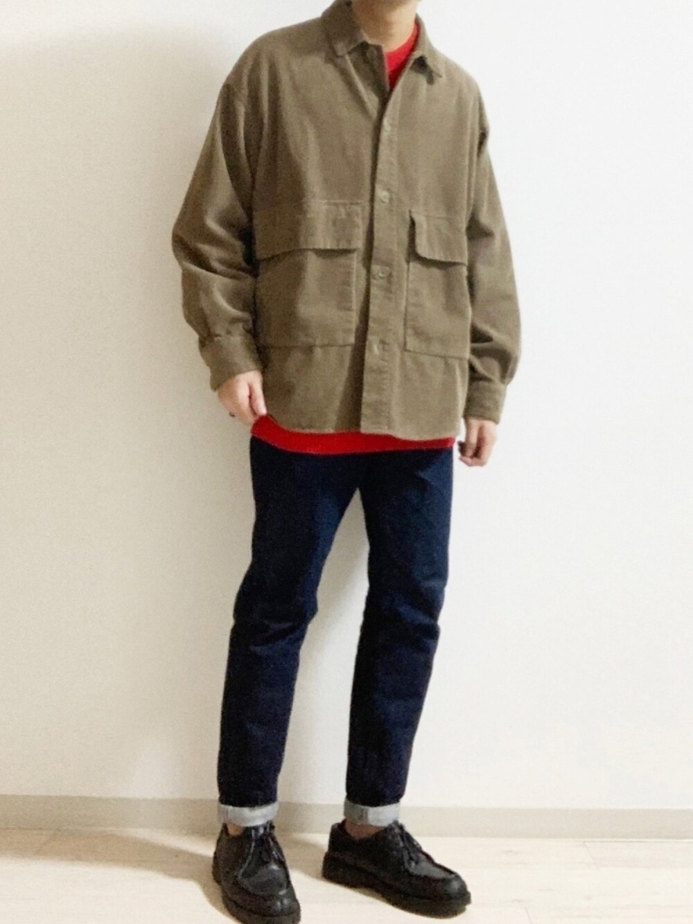 ベージュ系のブルゾン、ブルー系のデニムパンツ、レッド系のトップスを着用したメンズの冬コーディネートの1枚目の写真