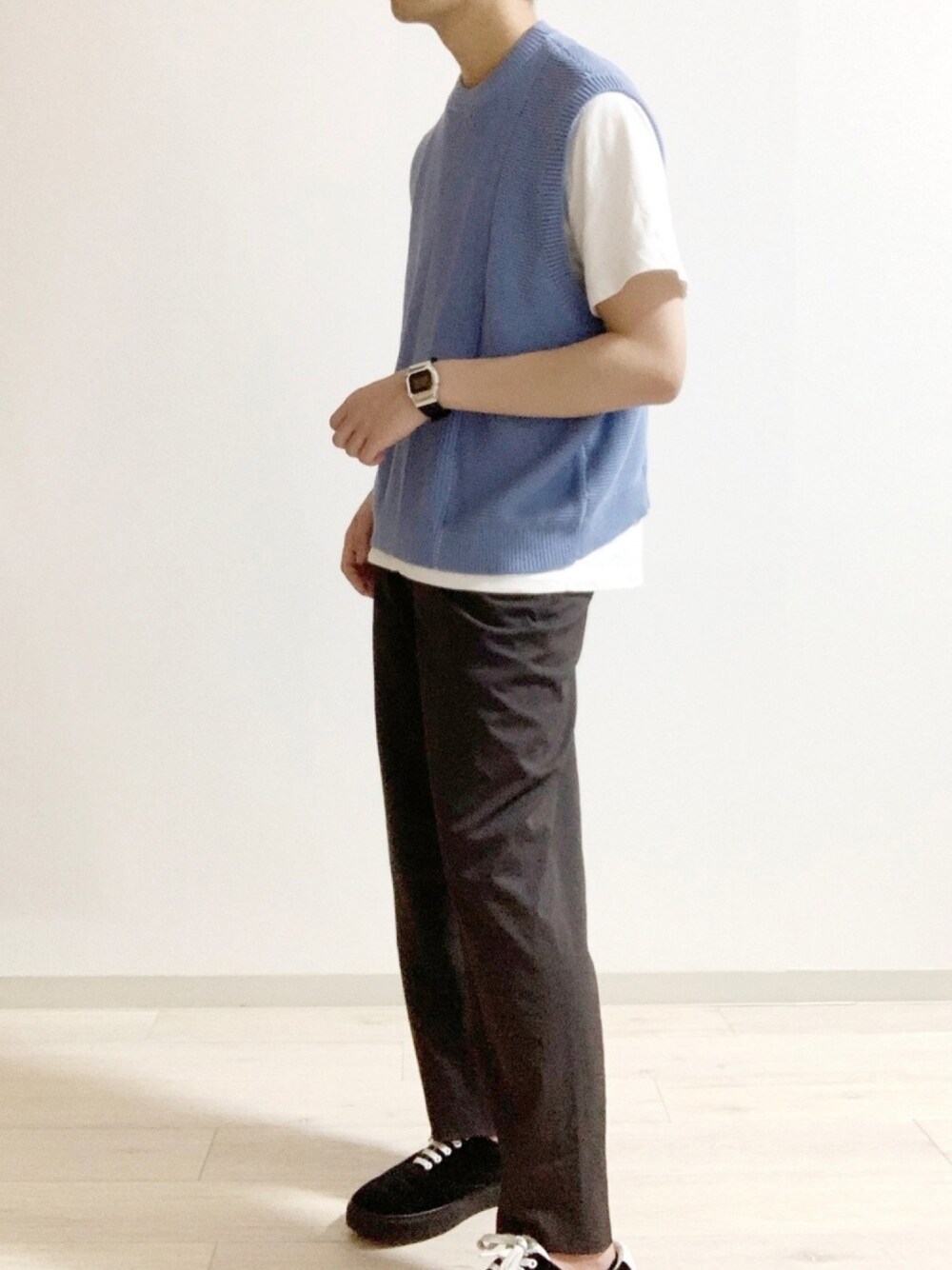 ブルー系のベスト、ブラウン系のその他パンツ、ブラック系のスニーカーを着用したメンズの春コーディネートの1枚目の写真