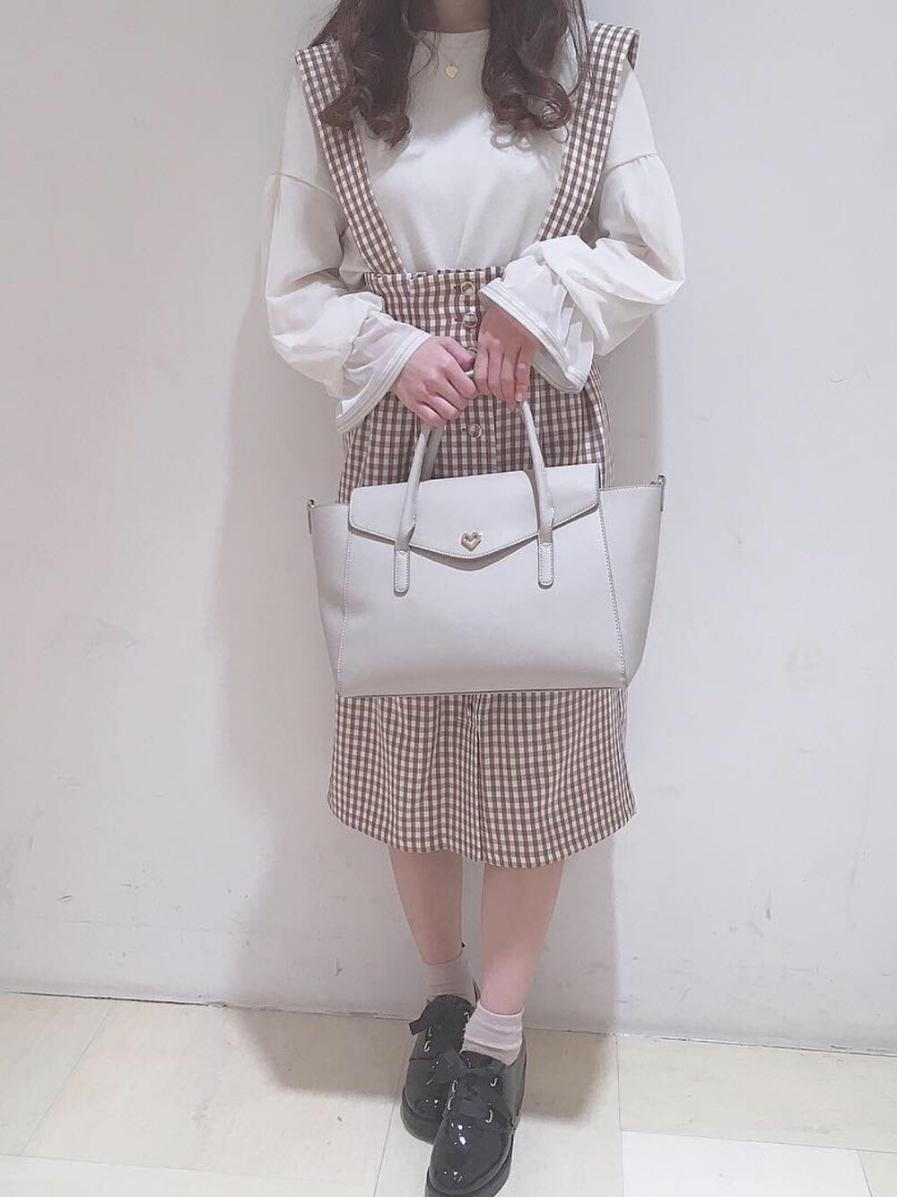 ホワイト系のTシャツ/カットソー、ブラウン系のスカート、グレー系のトートバッグを着用したレディースの冬コーディネートの1枚目の写真