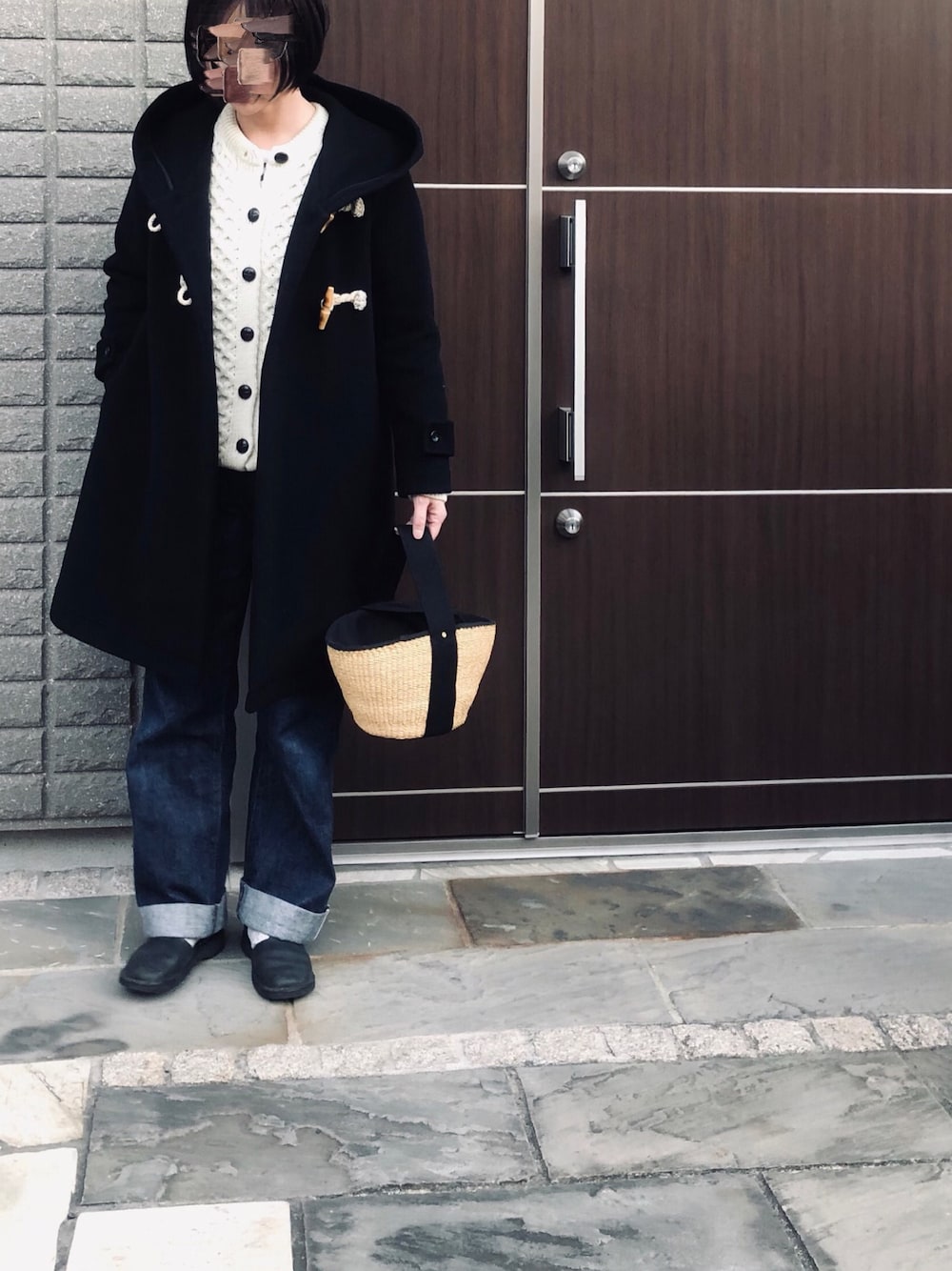 ホワイト系のニット/セーター、ブラック系のダッフルコート、ブルー系のデニムパンツを着用したレディースの冬コーディネートの1枚目の写真