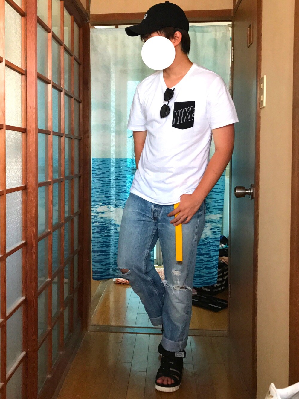 ホワイト系のTシャツ/カットソー、ブルー系のデニムパンツ、ブラック系のサンダルを着用したメンズの夏コーディネートの1枚目の写真