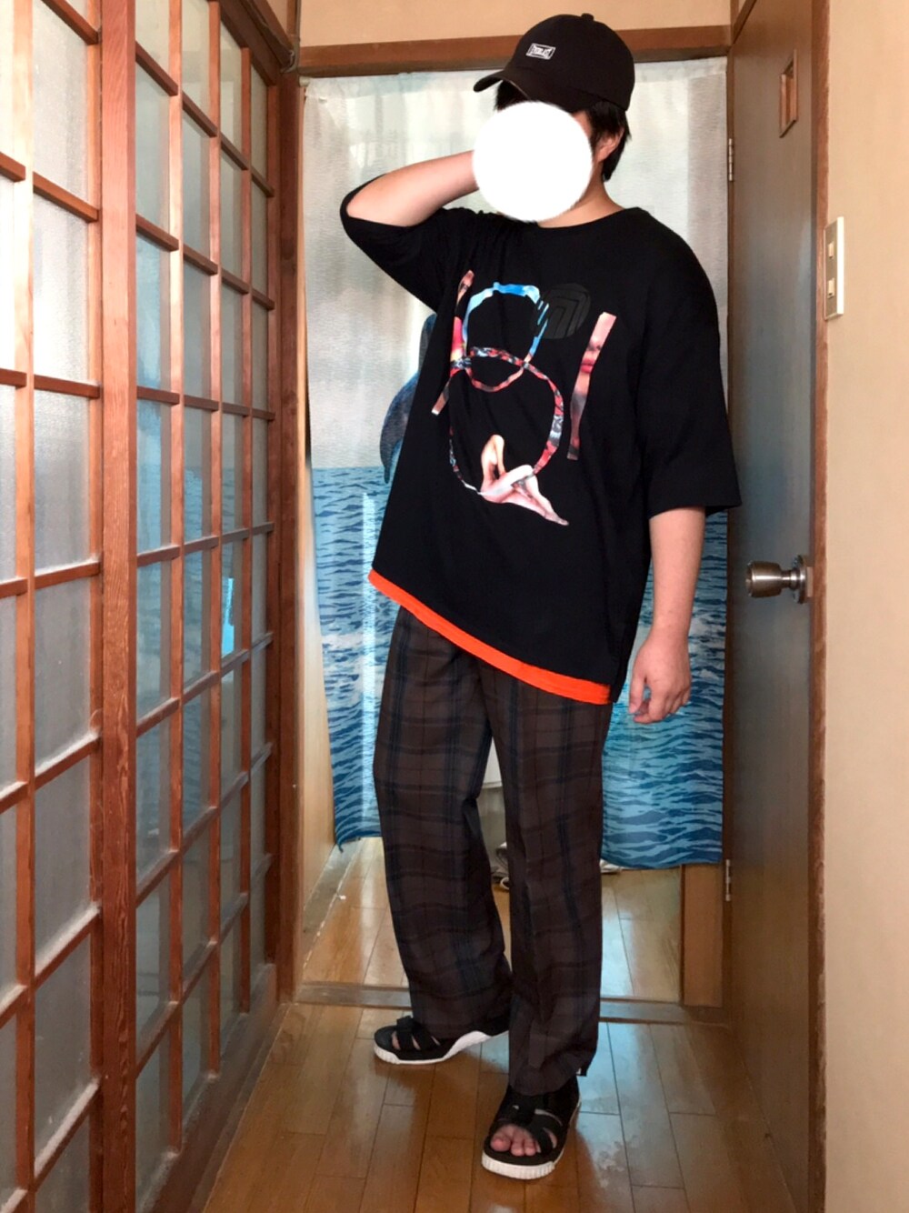 ブラック系のTシャツ/カットソー、ブラウン系のスラックス、ブラック系のサンダルを着用したメンズの夏コーディネートの1枚目の写真