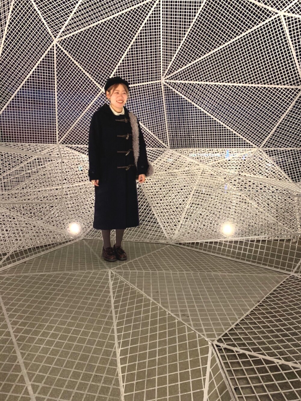 ブラック系のダッフルコート、ホワイト系のニット/セーター、ブラウン系のローファーを着用したレディースの冬コーディネートの1枚目の写真