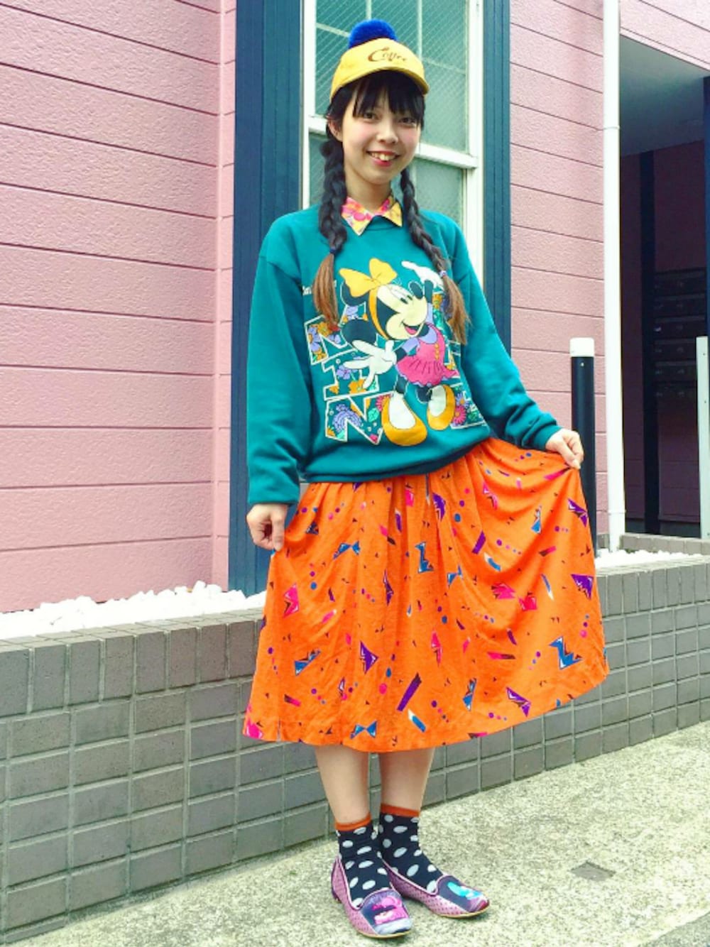 グリーン系のトップス、イエロー系のトップス、ピンク系のパンプスを着用したレディースの春コーディネートの1枚目の写真