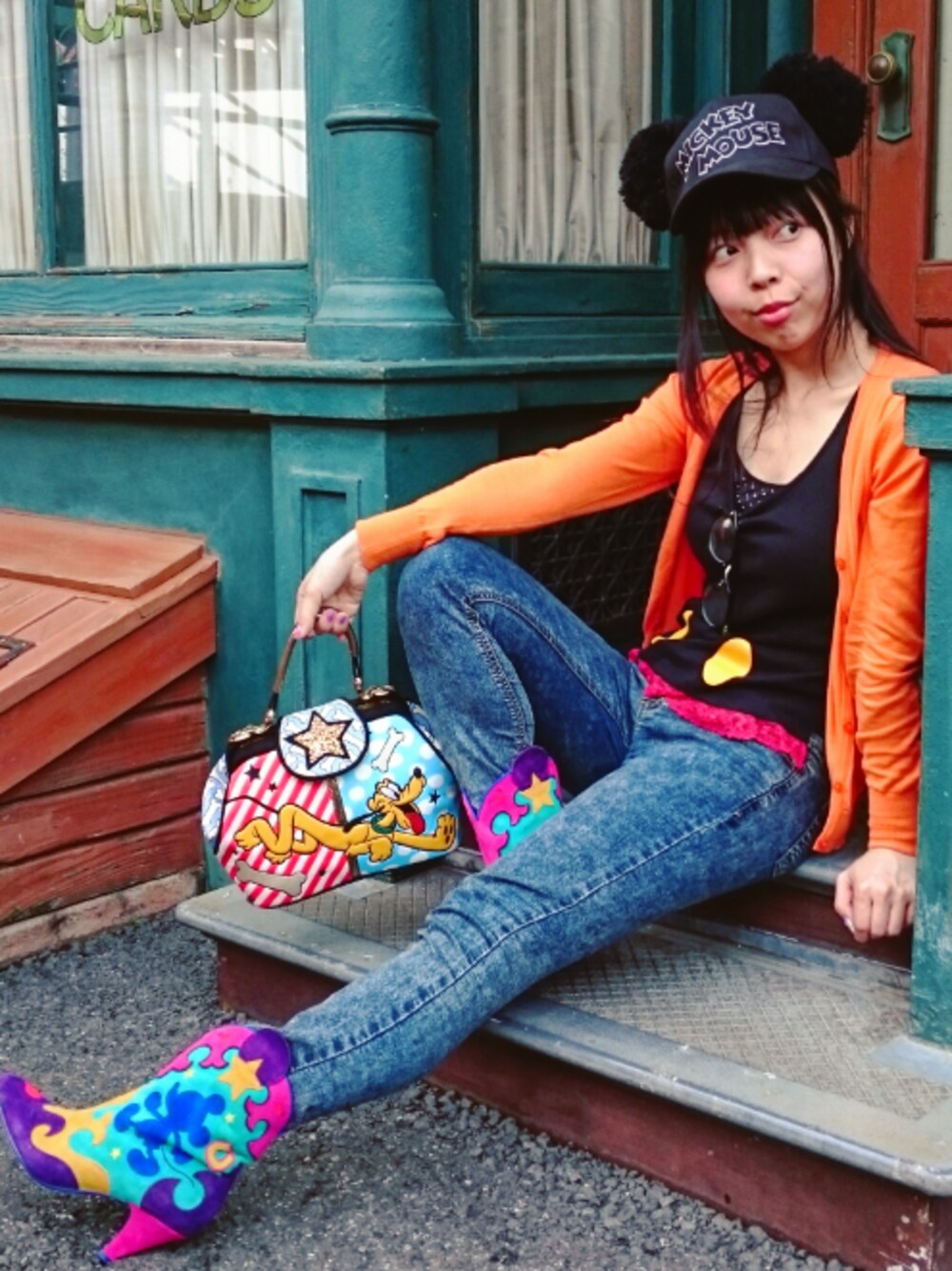 その他のブーツ、ブルー系のハンドバッグ、ブルー系のパンツを着用したレディースの夏コーディネートの1枚目の写真