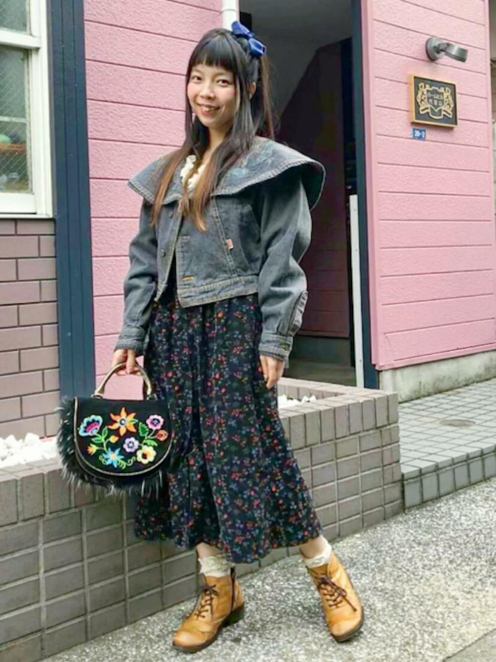 ブラック系のデニムジャケット、ブラック系のワンピース、ブラック系のハンドバッグを着用したレディースの秋コーディネートの1枚目の写真