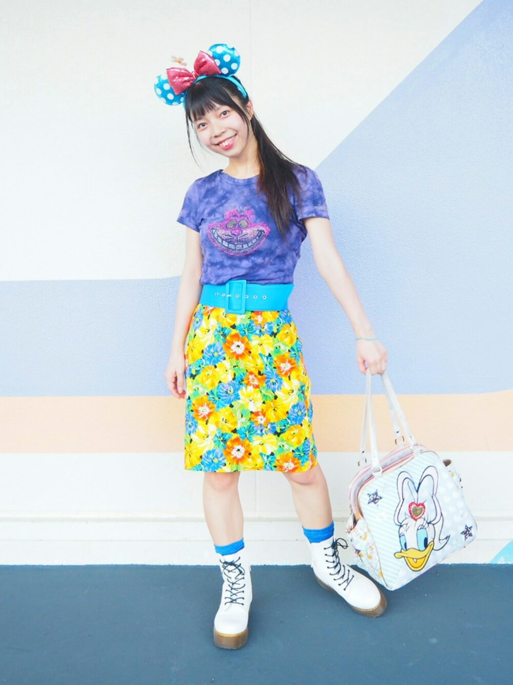 パープル系のTシャツ/カットソー、イエロー系のスカート、ホワイト系のブーツを着用したレディースの秋コーディネートの1枚目の写真