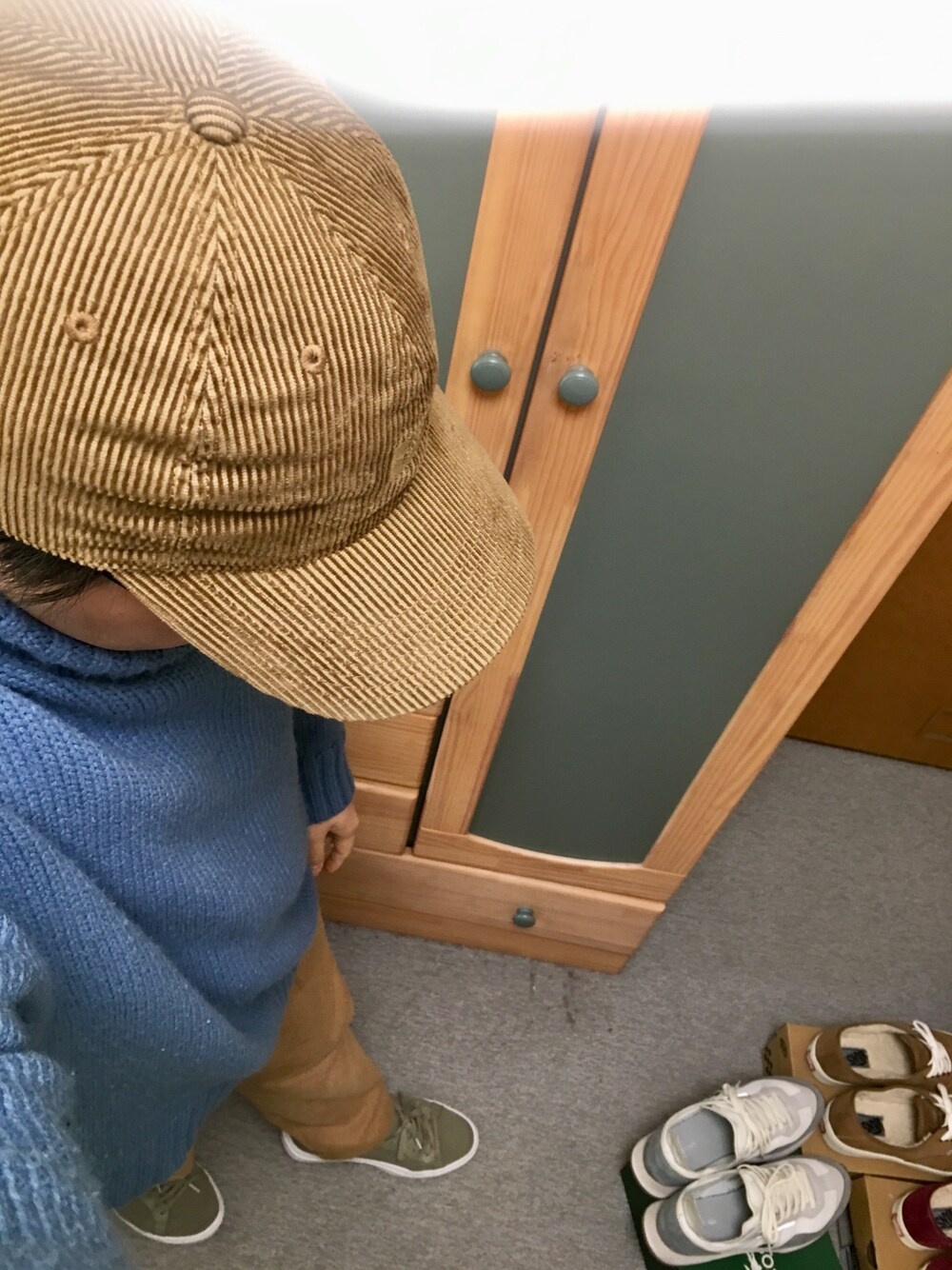 ブルー系のニット/セーター、ベージュ系のカーゴパンツ、グリーン系のスニーカーを着用したメンズの冬コーディネートの1枚目の写真