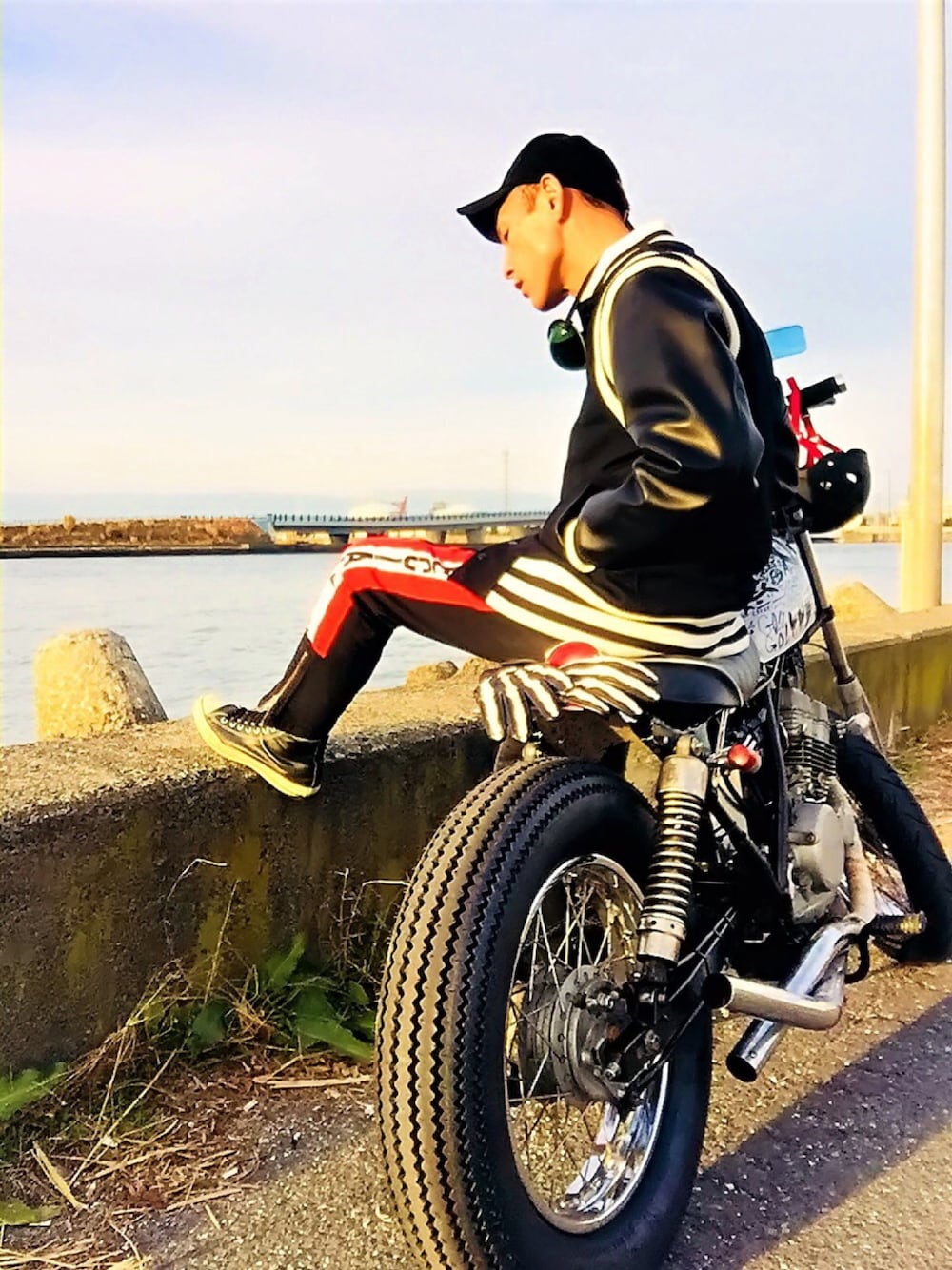 ブラック系のスタジャン、ブラック系のデニムパンツ、ブラック系のスニーカーを着用したメンズの冬コーディネートの1枚目の写真