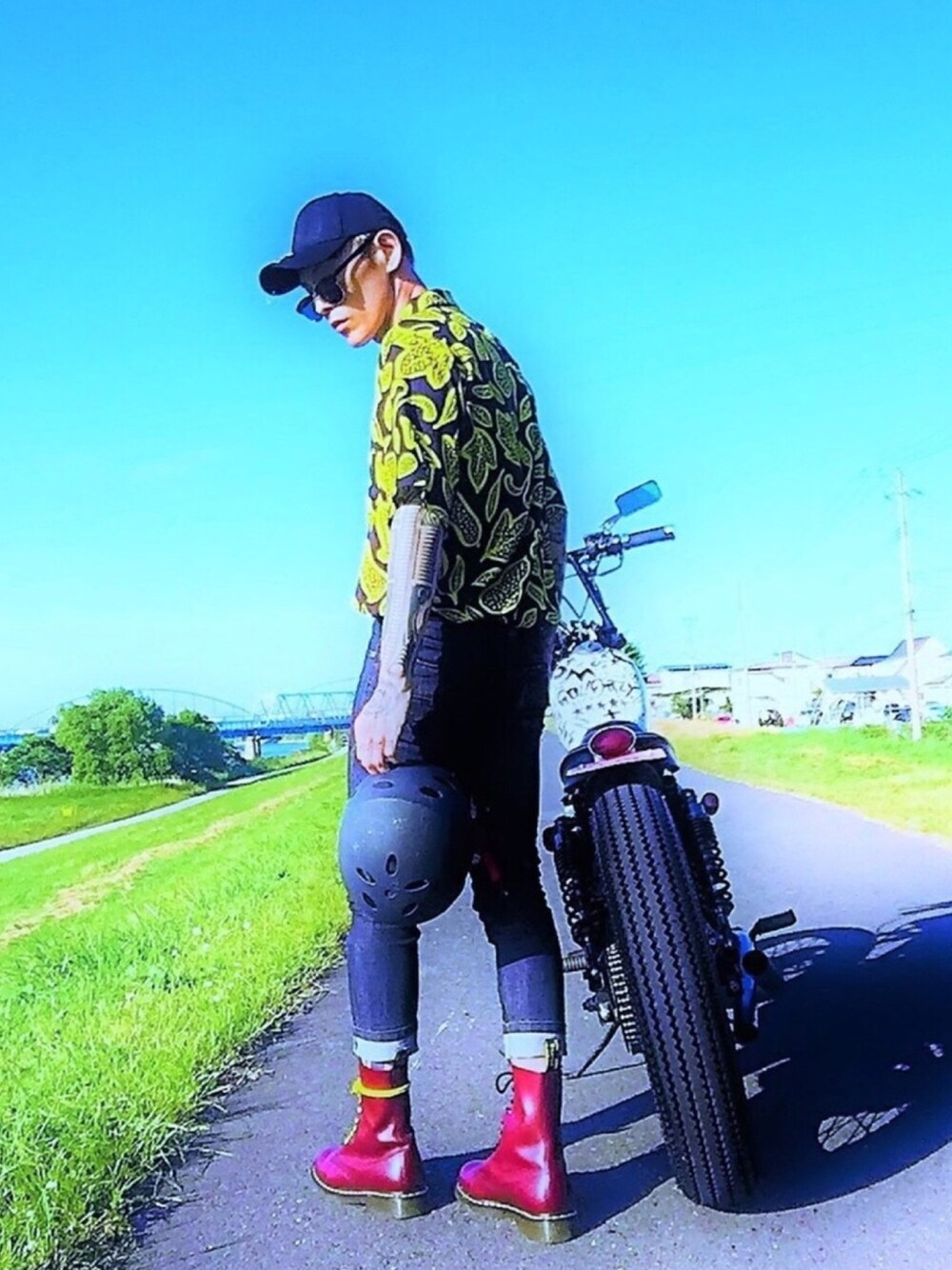 「not conventional、シャツスタイル、柄シャツ、タックイン、ブーツ、Dr.Martens、バイク、オープンカラーシャツ、キャップ、黒スキニー」｜「NOT CONVENTIONALのNOTCONVENTIONAL/BOTANICAL SHIRT（ポロシャツ、イエロー系）」を使った、TETUさん（メンズ・174cm）の夏コーディネートの1枚目の写真