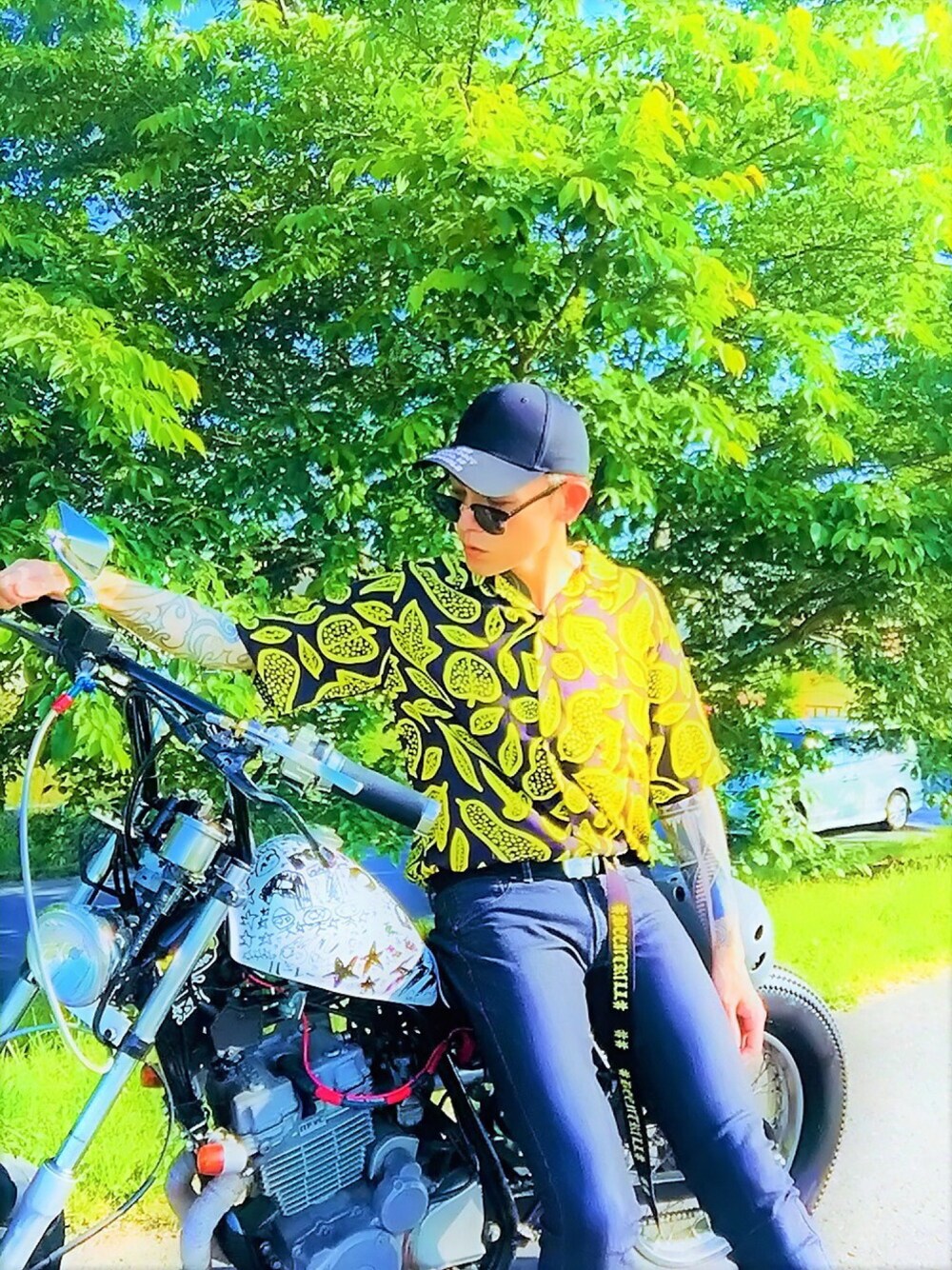 「not conventional、オープンカラーシャツ、柄シャツ、デニム、キャップ、サングラス、ブラック、夏コーデ、シャツスタイル、バイク」｜「NOT CONVENTIONALのNOTCONVENTIONAL/BOTANICAL SHIRT（ポロシャツ、イエロー系）」を使った、TETUさん（メンズ・174cm）の夏コーディネートの1枚目の写真