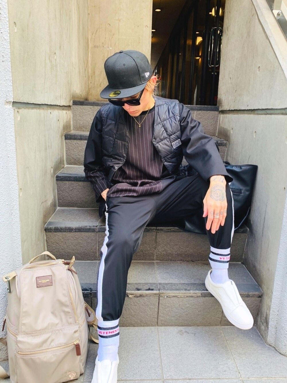 「ブラック、白スニーカー、ストリート、ラインパンツ、バックパック、USポロ、NUMBER (N)INE、not conventional、ダウンベスト、インナーダウン」｜「U.S. POLO ASSN.の【U.S. POLO ASSN.】 ユーエスポロアッスン　ナイロンリュック  US1909（バックパック/リュック、グレー系）」を使った、TETUさん（メンズ・174cm）の冬コーディネートの1枚目の写真