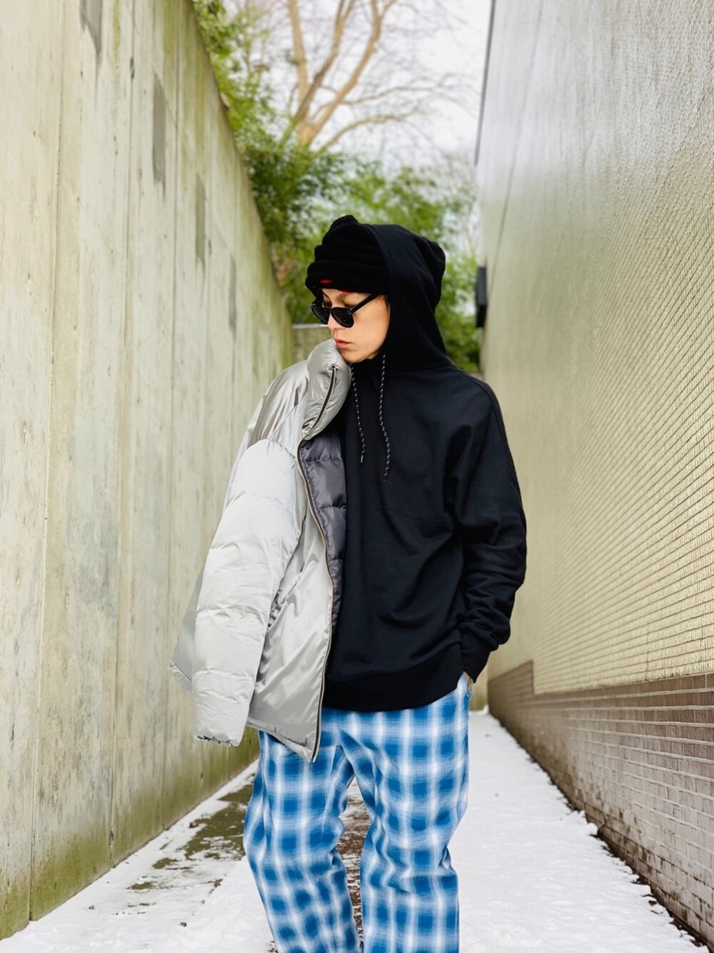 「チェックパンツ、パーカー、DEVILOCK、ダウンジャケット、メタリック、NUMBER (N)INE、ストリートMIX、ニット帽、オーバーサイズ、ストリート」｜「DEVILOCKの【DEVILOCK】《別注》ビッグカラーロゴバックプリントスウェットパーカー（パーカー、ブラック系）」を使った、TETUさん（メンズ・174cm）の春コーディネートの1枚目の写真