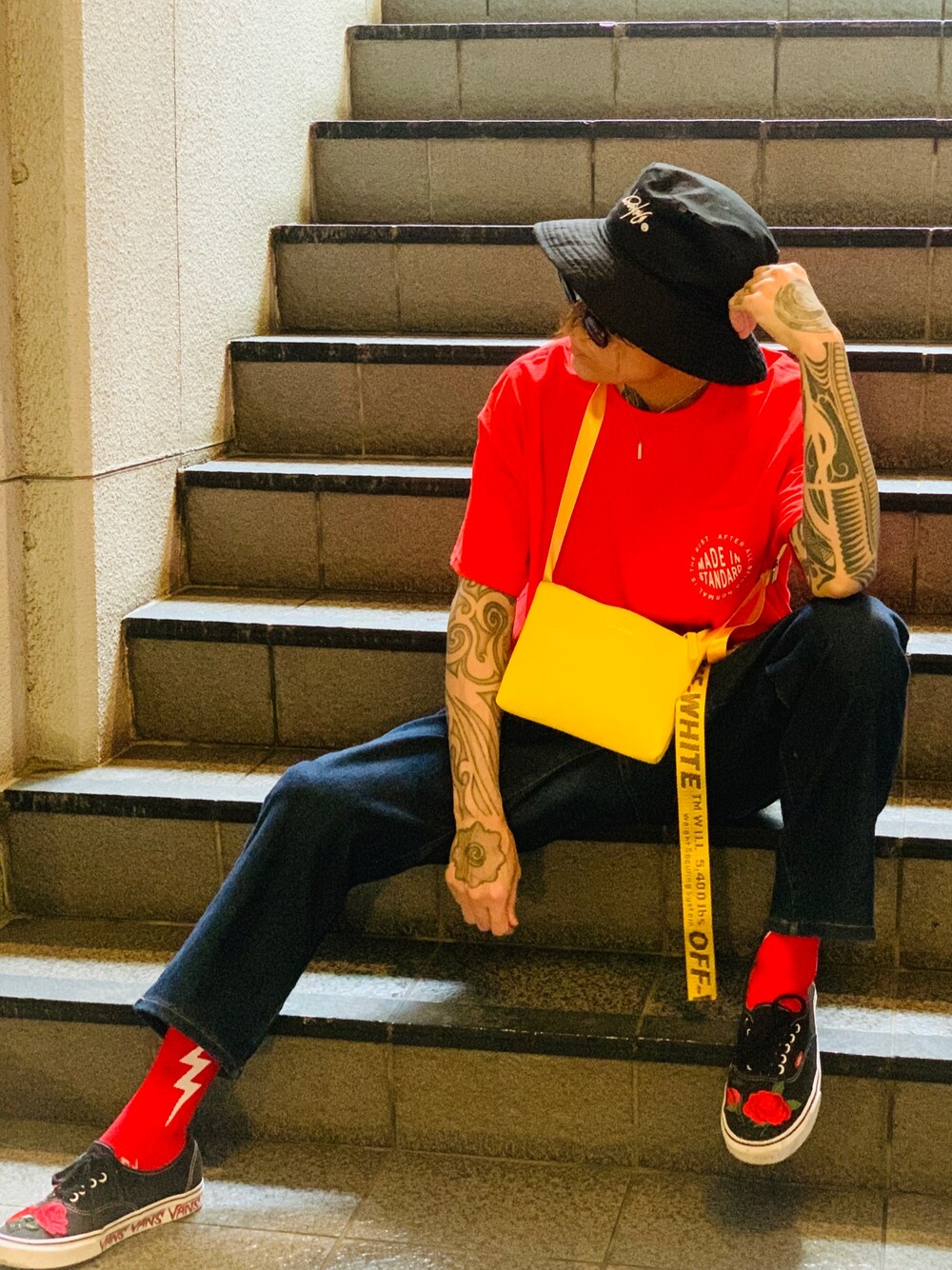 「サコッシュ、NUMBER (N)INE、バケットハット、赤、Tシャツ、made in standard、スニーカー、VANS、ワイドデニム、タックイン」｜「NUMBER (N)INEの【NUMBER (N)INE】≪WEB限定≫別注スーベニアプレミアムPUレザーサコッシュ（ショルダーバッグ、イエロー系）」を使った、TETUさん（メンズ・175cm）の夏コーディネートの1枚目の写真
