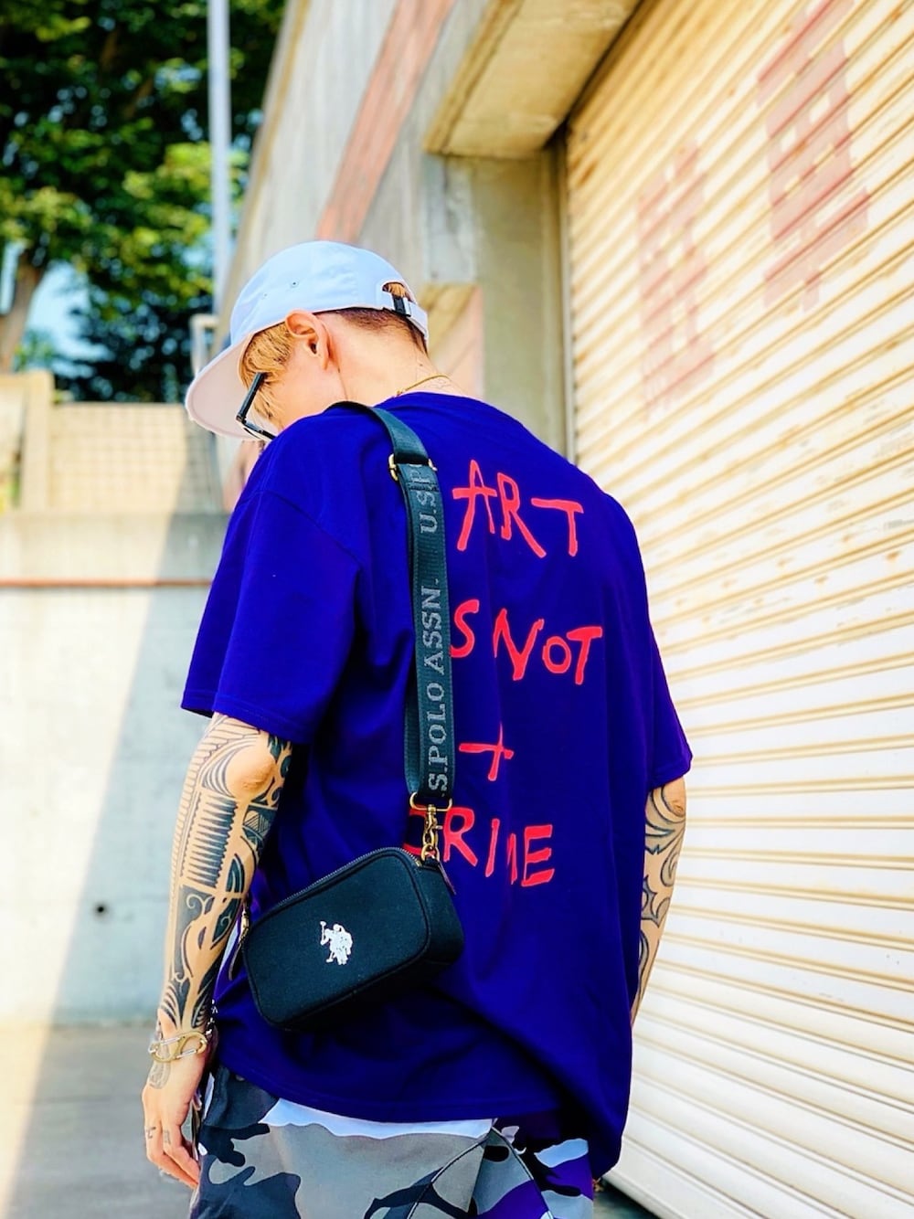 「CASPER JOHN AIVER、AIVER、パープル、迷彩パンツ、カモフラ、USポロ、uspolo、ショルダーバッグ、バックプリント、バックスタイル」｜「AIVERのCASPER JOHN AIVER　ART IS NOT A CRIME ビッグTシャツ（Tシャツ/カットソー、パープル系）」を使った、TETUさん（メンズ・174cm）の夏コーディネートの1枚目の写真