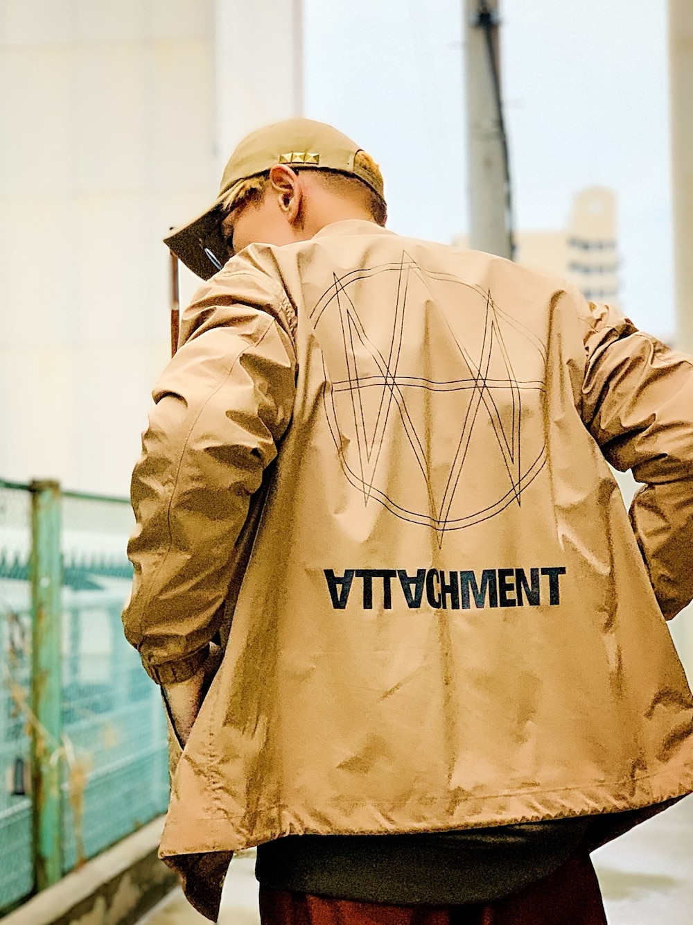 「ATTACHMENT、コーチジャケット、ベージュ、ブラウン、ラフ、キャップ、ストリート、street、アウトドアスタイル」｜「ATTACHMENTの【ATTACHMENT】《WEB限定》ジオメトリックプリントコーチジャケット（ナイロンジャケット、ブラウン系）」を使った、TETUさん（メンズ・174cm）の春コーディネートの1枚目の写真