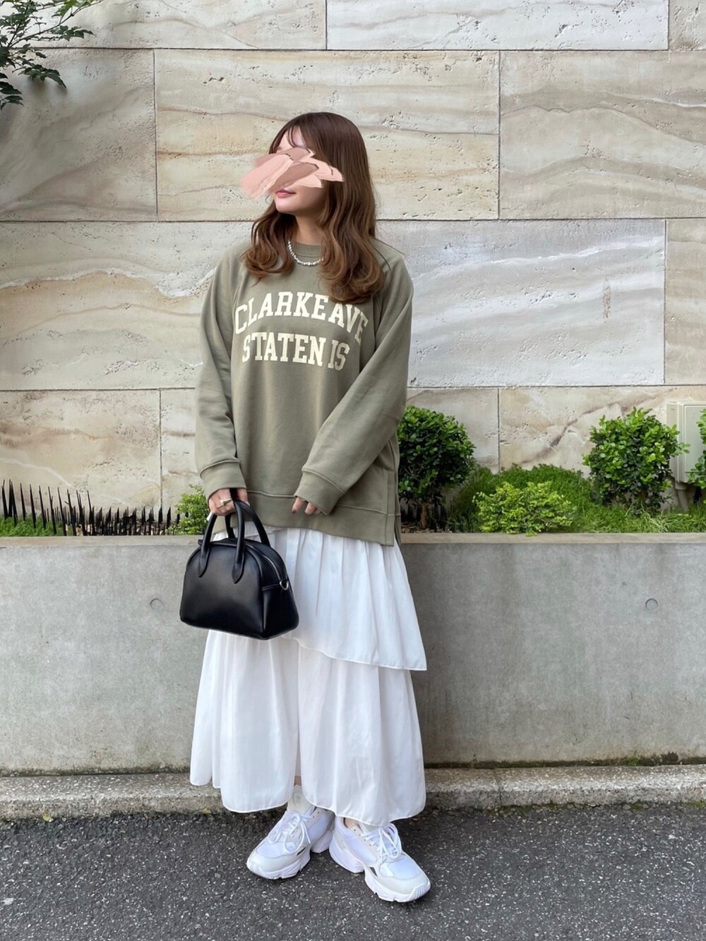 グリーン系のスウェット、ホワイト系のスカート、ホワイト系のスニーカーを着用したレディースの春コーディネートの1枚目の写真