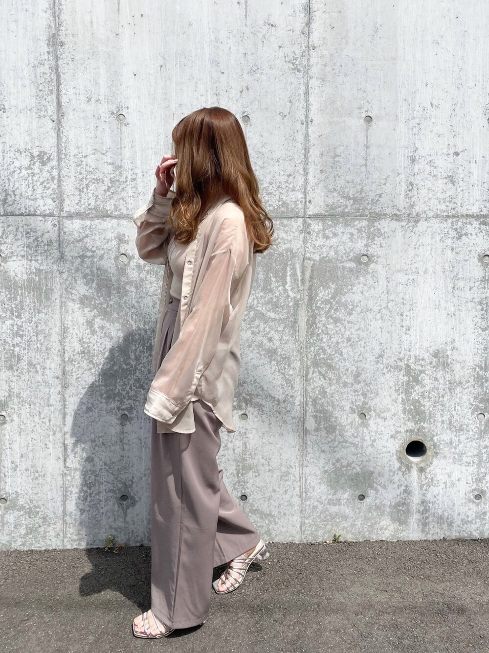 ベージュ系のシャツ/ブラウス、グレー系のスラックス、シルバー系のサンダルを着用したレディースの春コーディネートの1枚目の写真