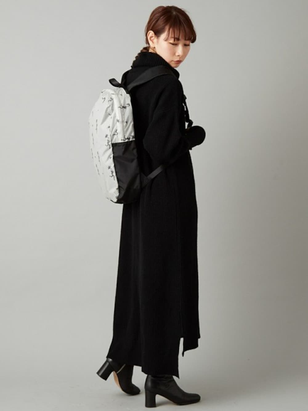 ホワイト系のバックパック/リュック、ブラック系のワンピースを着用したレディースの秋コーディネートの1枚目の写真