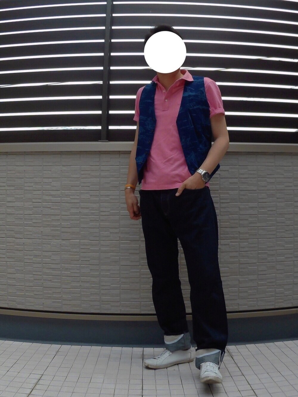 ブルー系のベスト、ピンク系のポロシャツ、ブルー系のデニムパンツを着用したメンズの夏コーディネートの1枚目の写真