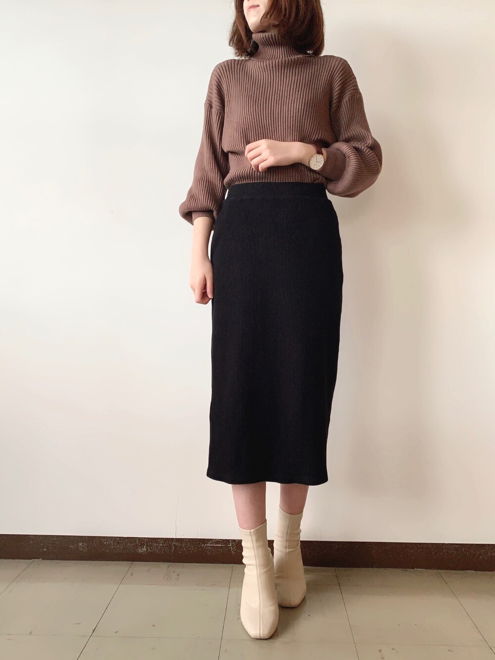 ブラウン系のニット/セーター、ホワイト系のブーツ、ブラウン系のアナログ腕時計を着用したレディースの冬コーディネートの1枚目の写真