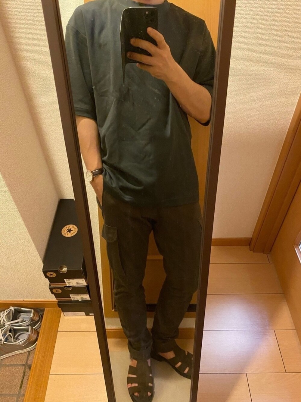 グレー系のTシャツ/カットソー、グリーン系のカーゴパンツ、ブラウン系のサンダルを着用したメンズの夏コーディネートの1枚目の写真