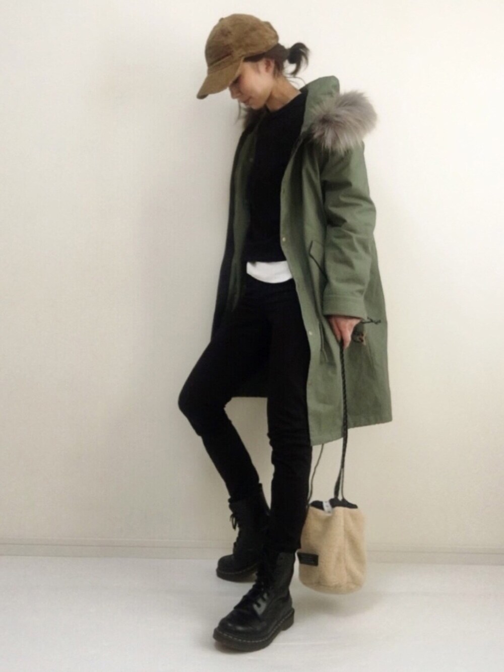 グリーン系のモッズコート、ブラック系のTシャツ/カットソー、ブルー系のショルダーバッグを着用したレディースの冬コーディネートの1枚目の写真