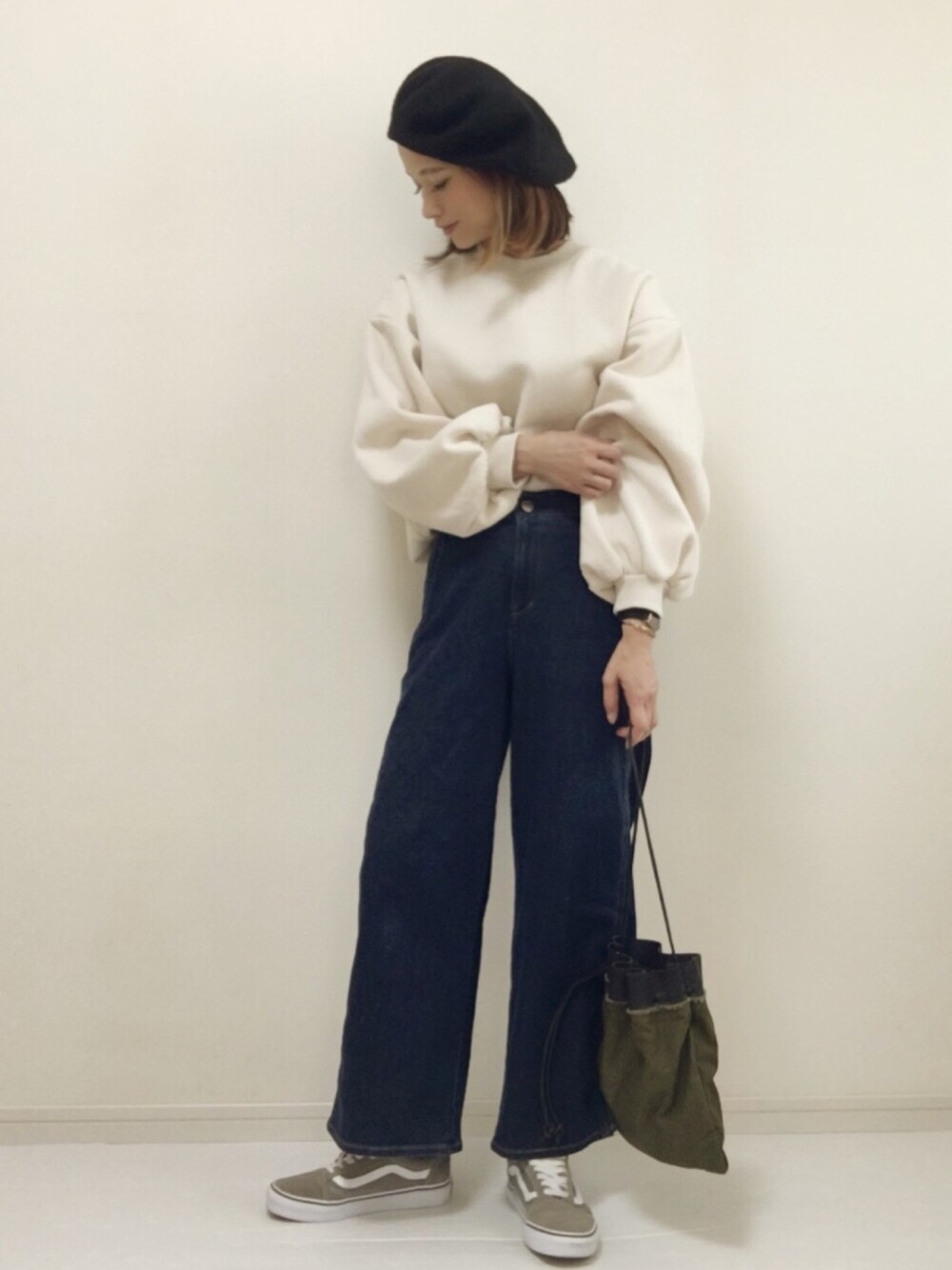 ブルー系のデニムパンツ、ホワイト系のスウェット、ベージュ系のスニーカーを着用したレディースの秋コーディネートの1枚目の写真