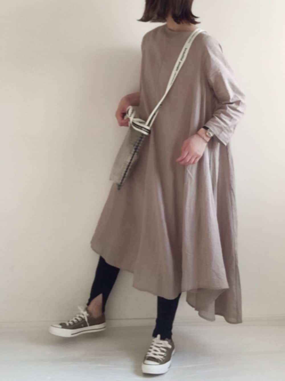 ベージュ系のワンピース、ブラック系のショルダーバッグ、ブラウン系のスニーカーを着用したレディースの春コーディネートの1枚目の写真