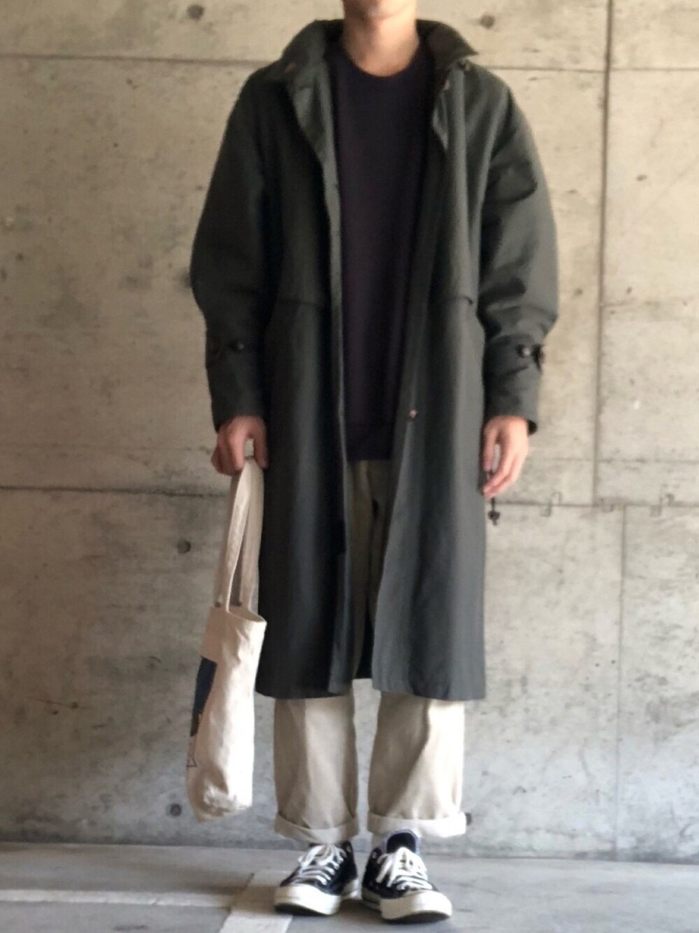 グレー系のスウェット、ホワイト系のトートバッグ、ブラック系のスニーカーを着用したメンズの秋コーディネートの1枚目の写真