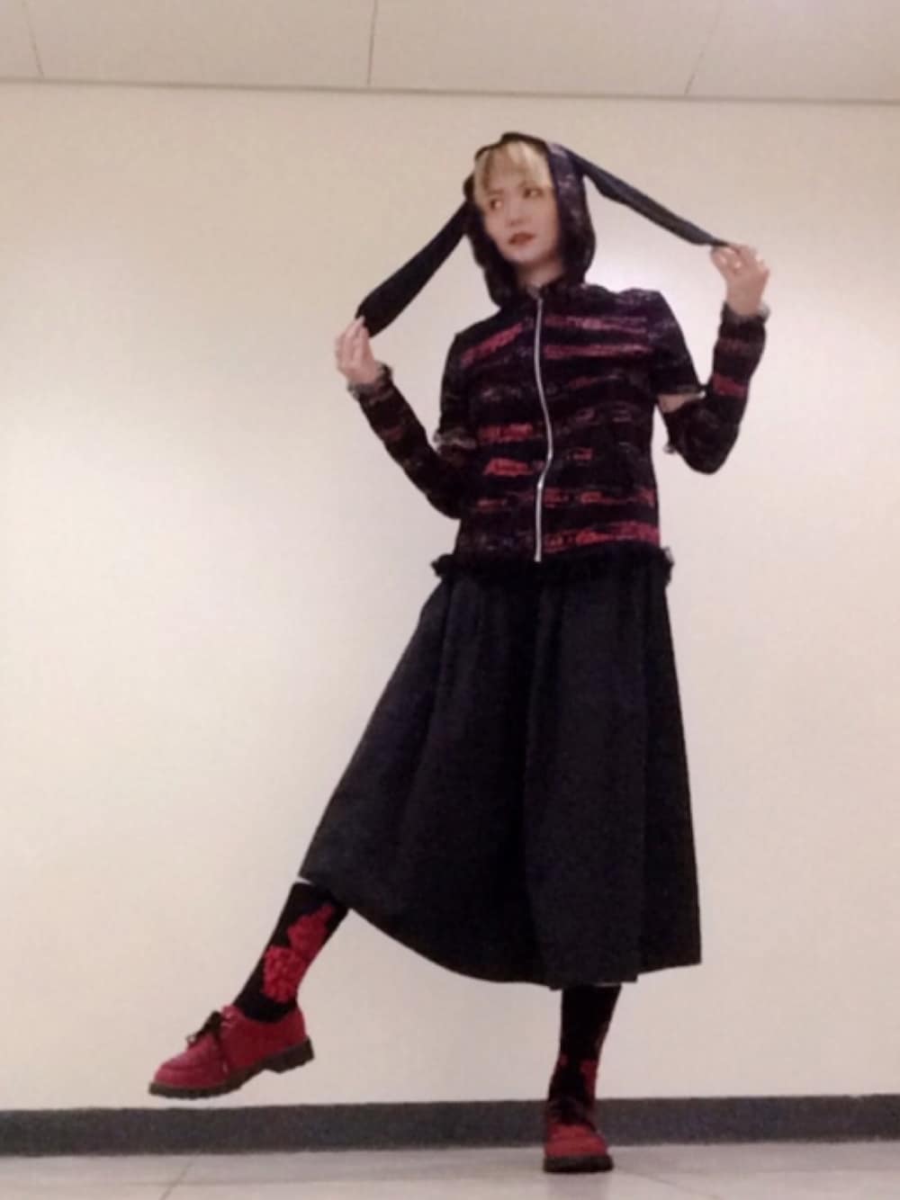 ブラック系のスカート、ブラック系のトップス、レッド系のシューズを着用したレディースの夏コーディネートの1枚目の写真