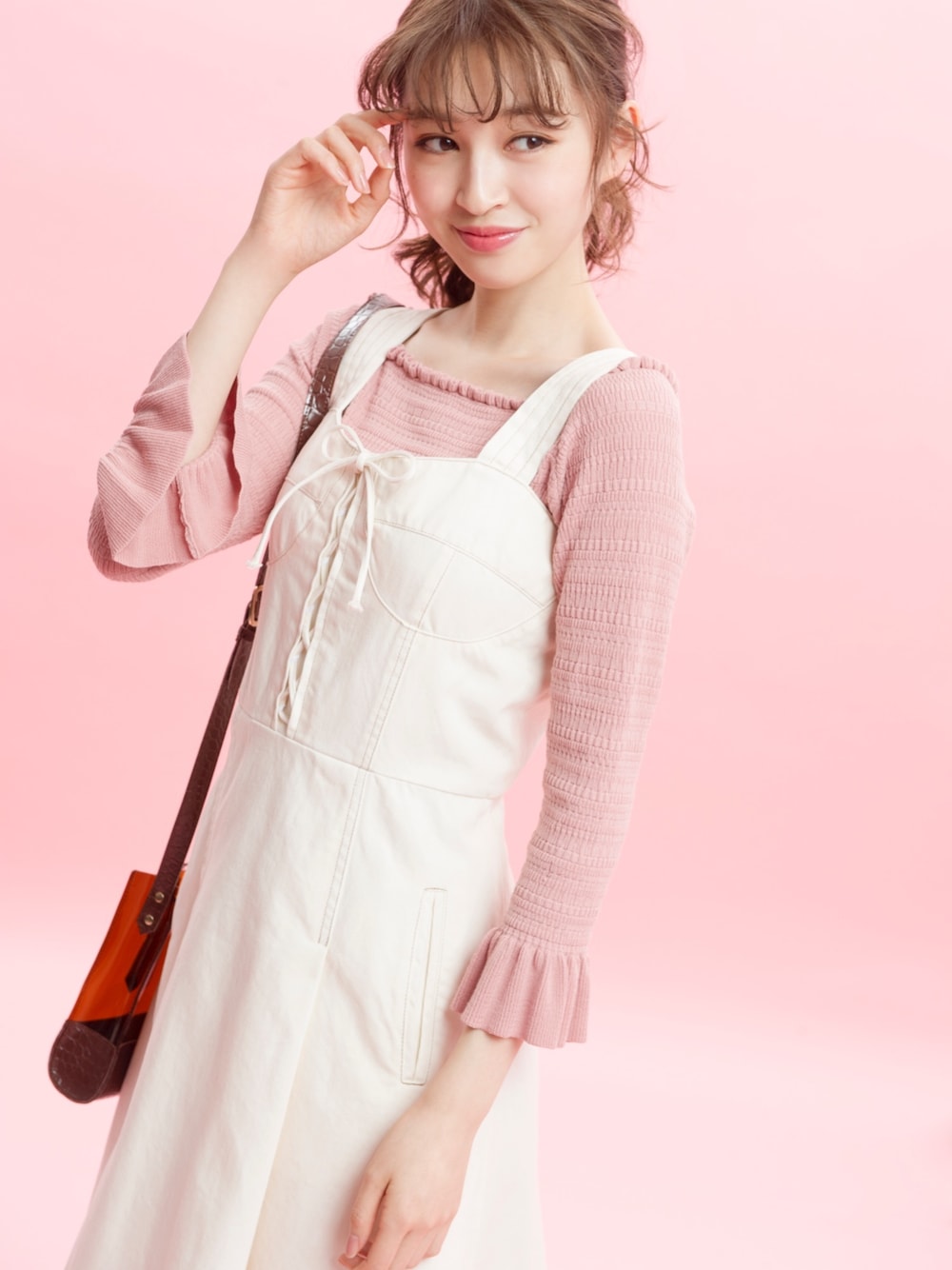 ホワイト系のワンピース、ピンク系のニット/セーター、ブラウン系のショルダーバッグを着用したレディースの春コーディネートの1枚目の写真