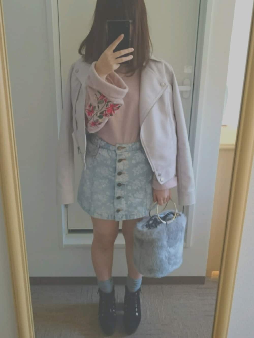 ピンク系のライダースジャケット、ピンク系のニット/セーター、ブルー系のスカートを着用したレディースの春コーディネートの1枚目の写真