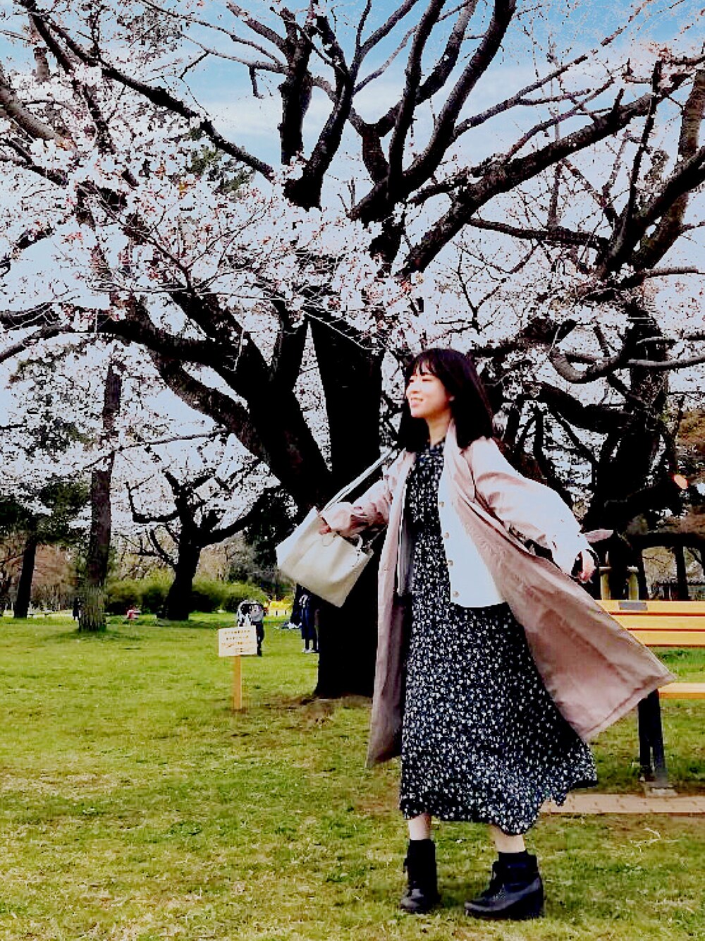 ベージュ系のトレンチコート、ブルー系のワンピース、ホワイト系のカーディガン/ボレロを着用したレディースの春コーディネートの1枚目の写真