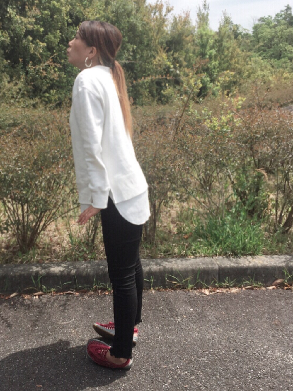 ホワイト系のニット/セーター、ブラック系のデニムパンツ、レッド系のサンダルを着用したレディースの春コーディネートの1枚目の写真