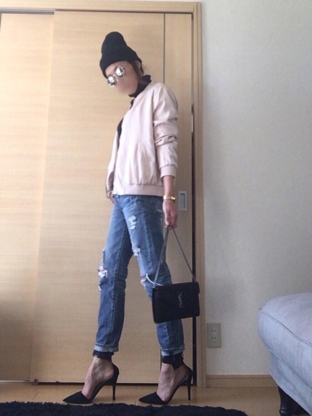 ピンク系のミリタリージャケット、ブルー系のデニムパンツ、ブラック系のショルダーバッグを着用したレディースの冬コーディネートの1枚目の写真